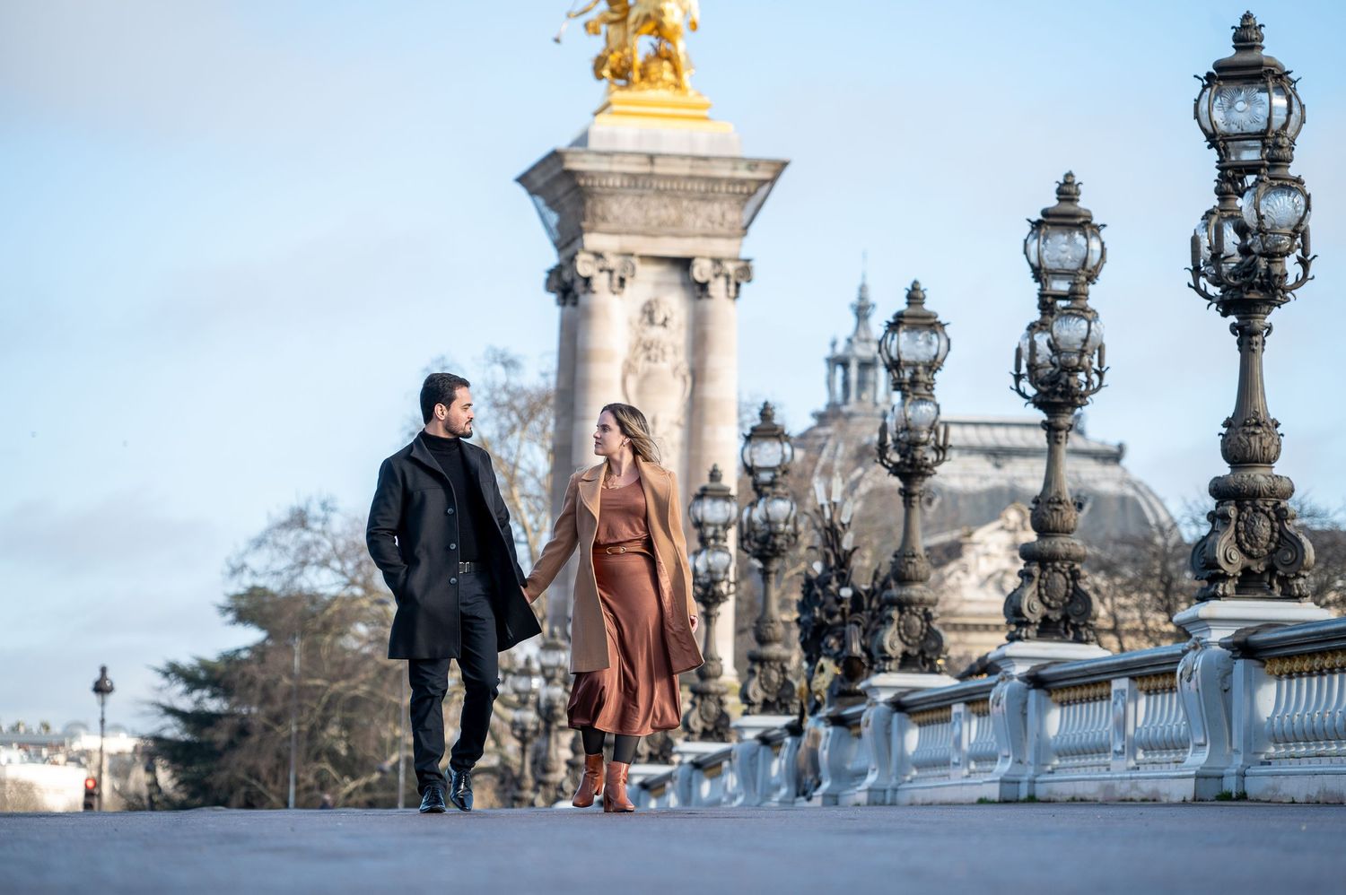 A romantic walk along the Alexandre III bridge with its iconic gold statues and lampposts in Paris.