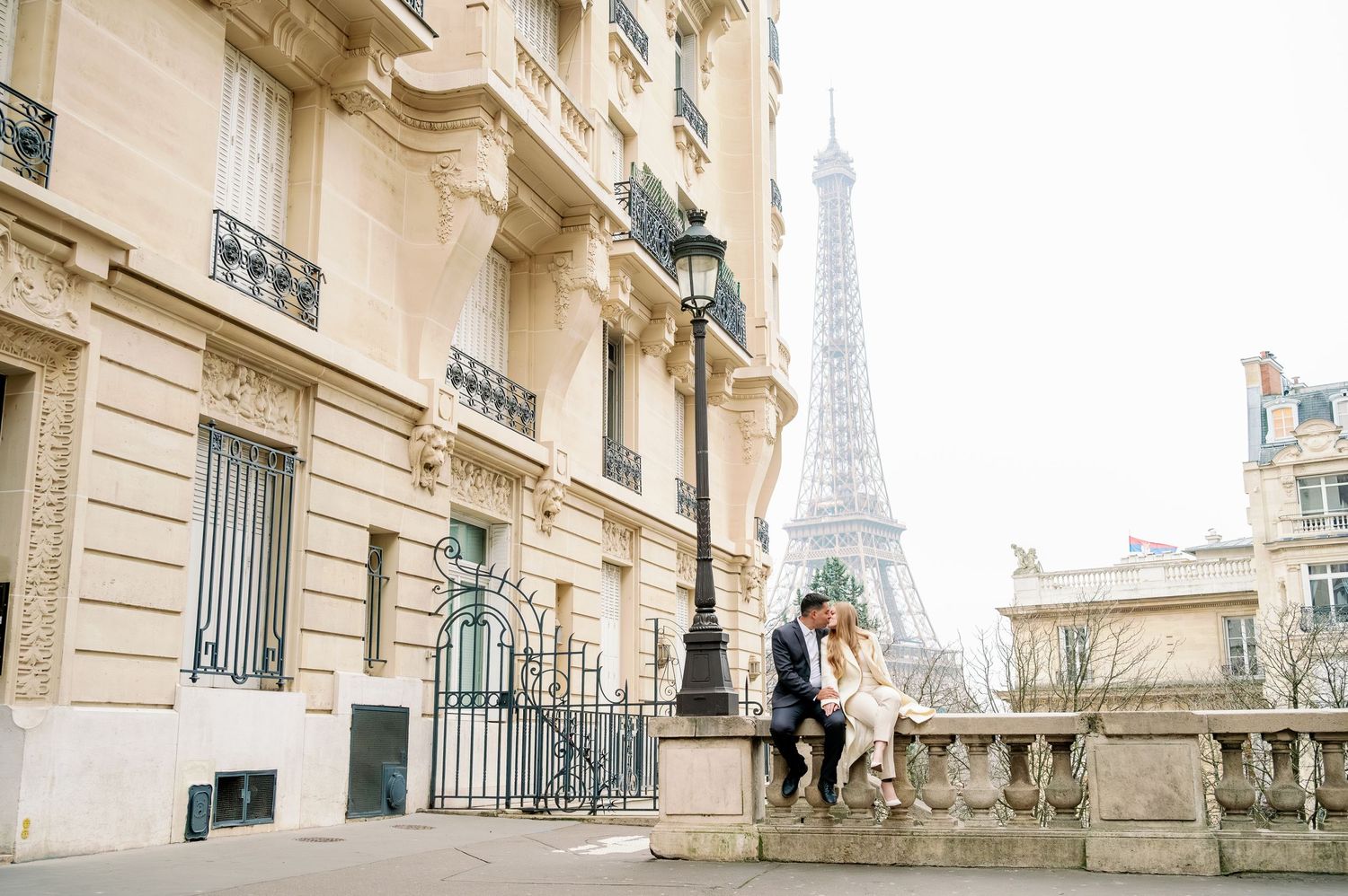 Romantic moment on a Parisian balcony with the iconic Eiffel Tower in the distance.