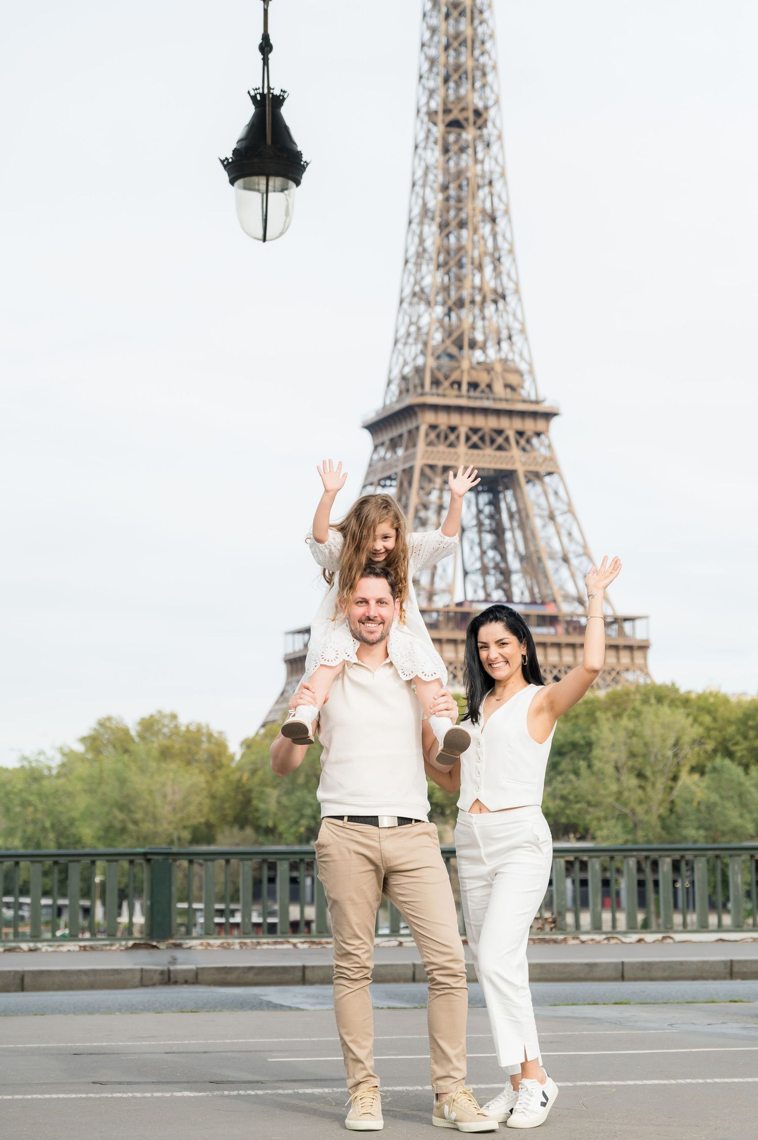 A couple enjoying a joyful stroll near the iconic Eiffel Tower in Paris on a sunny day.