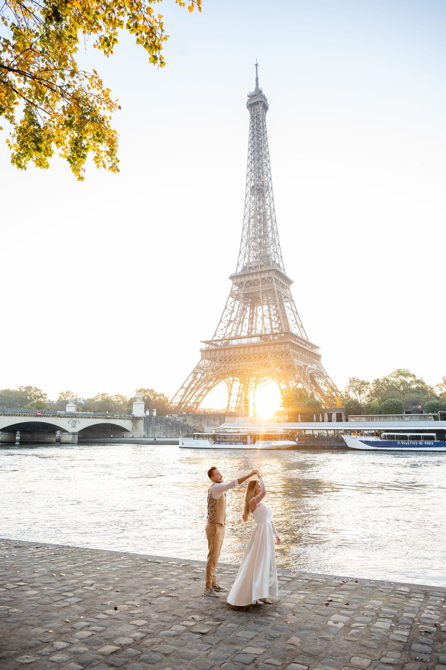 A romantic scene by the Seine River in Paris with the iconic Eiffel Tower and golden sunset in the background.