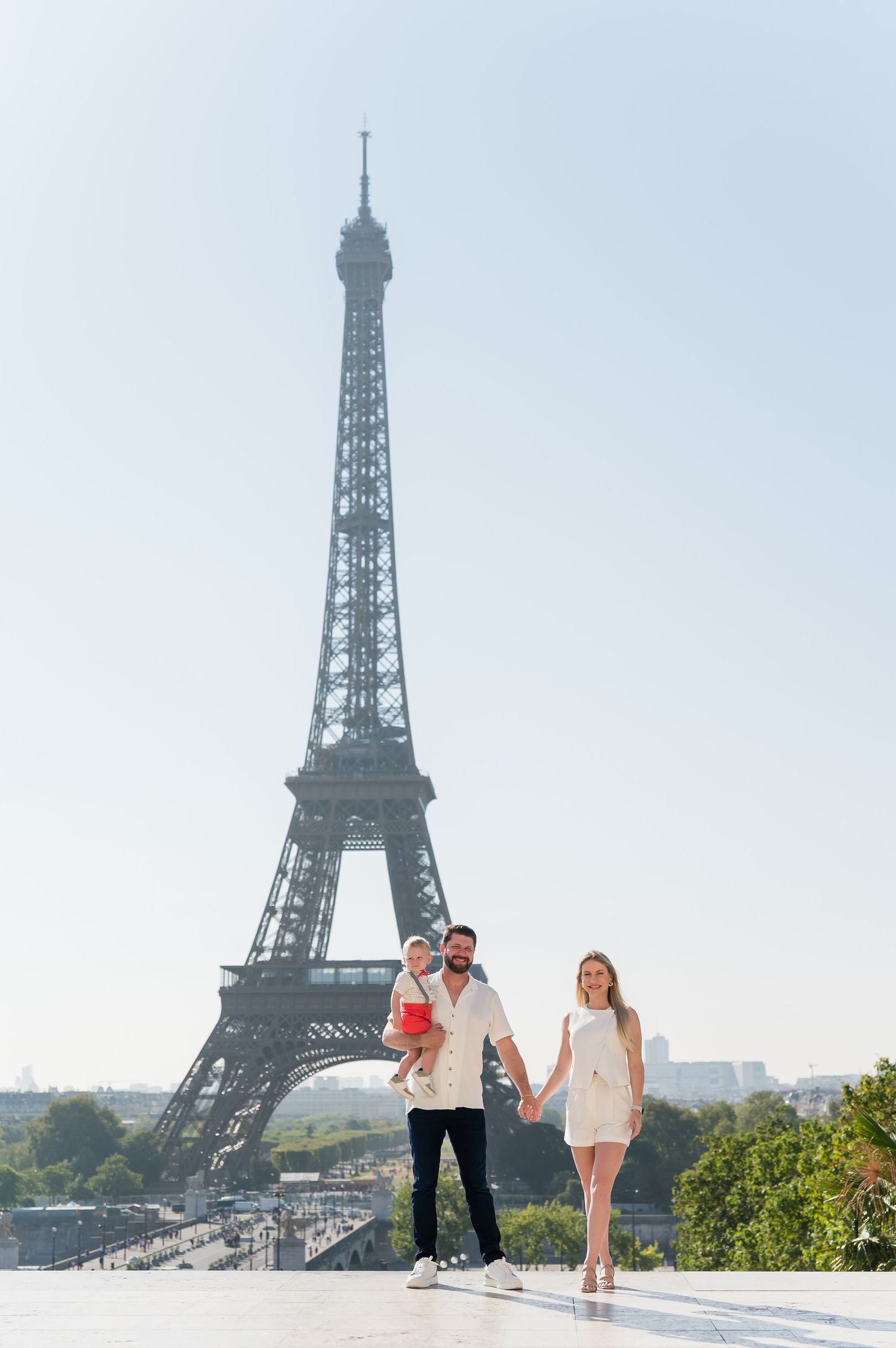 People walking and enjoying the scenic view with the iconic Eiffel Tower standing majestically in Paris, France.