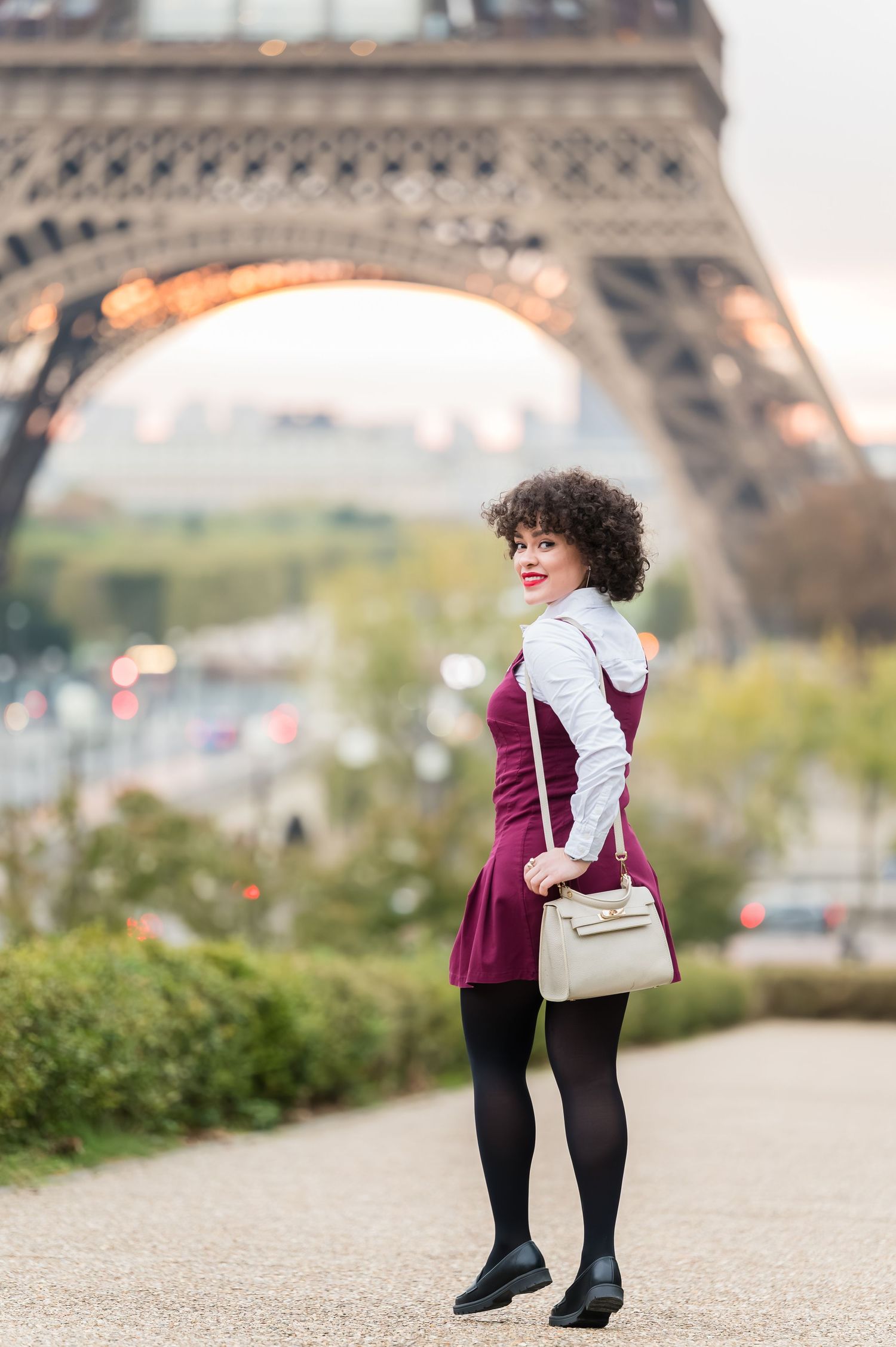 A person in a burgundy blazer and black tights poses near the Eiffel Tower in Paris across multiple shots.