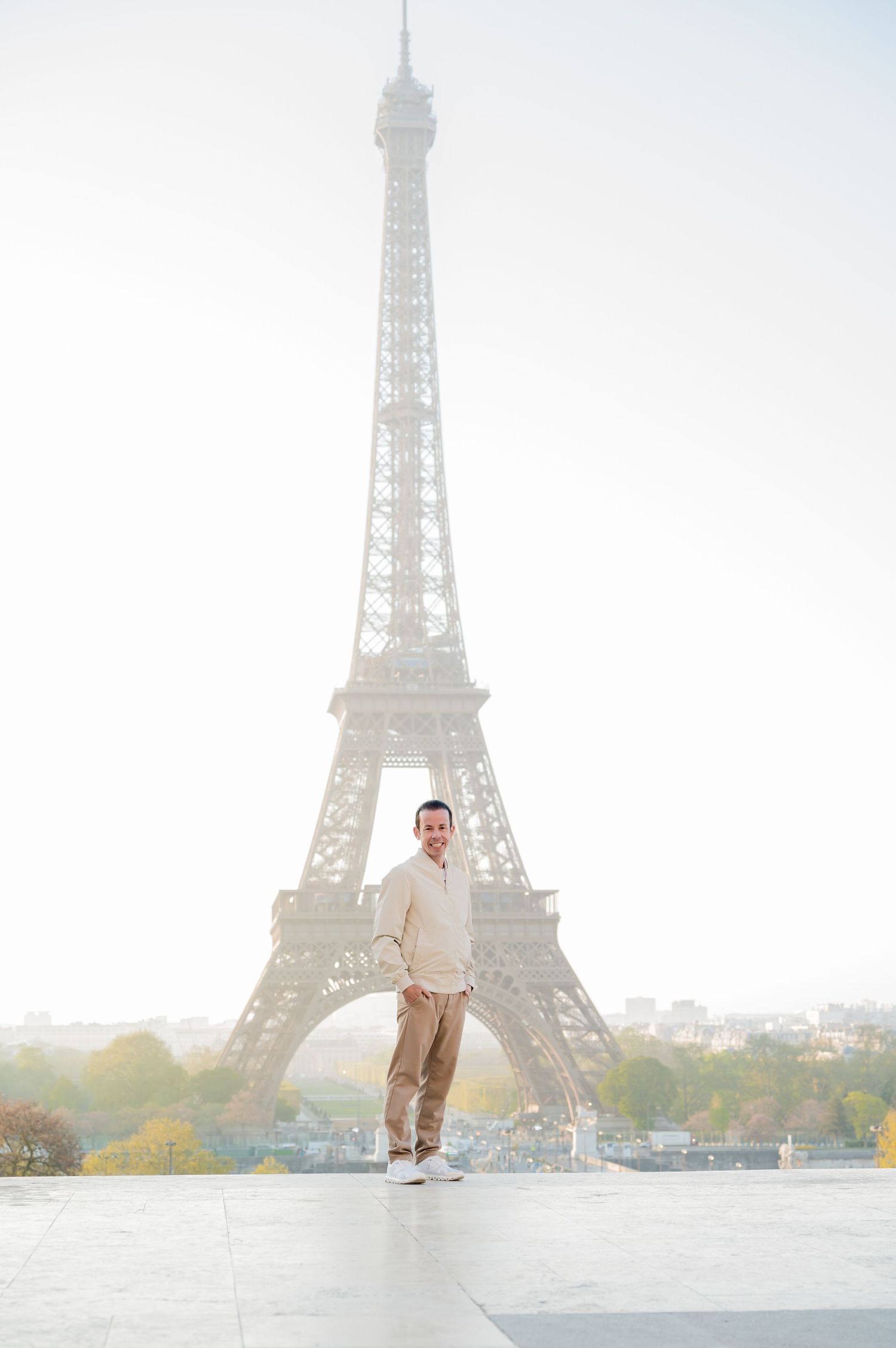 A series of connected shots showing someone jumping and posing in front of the Eiffel Tower in Paris during sunrise.