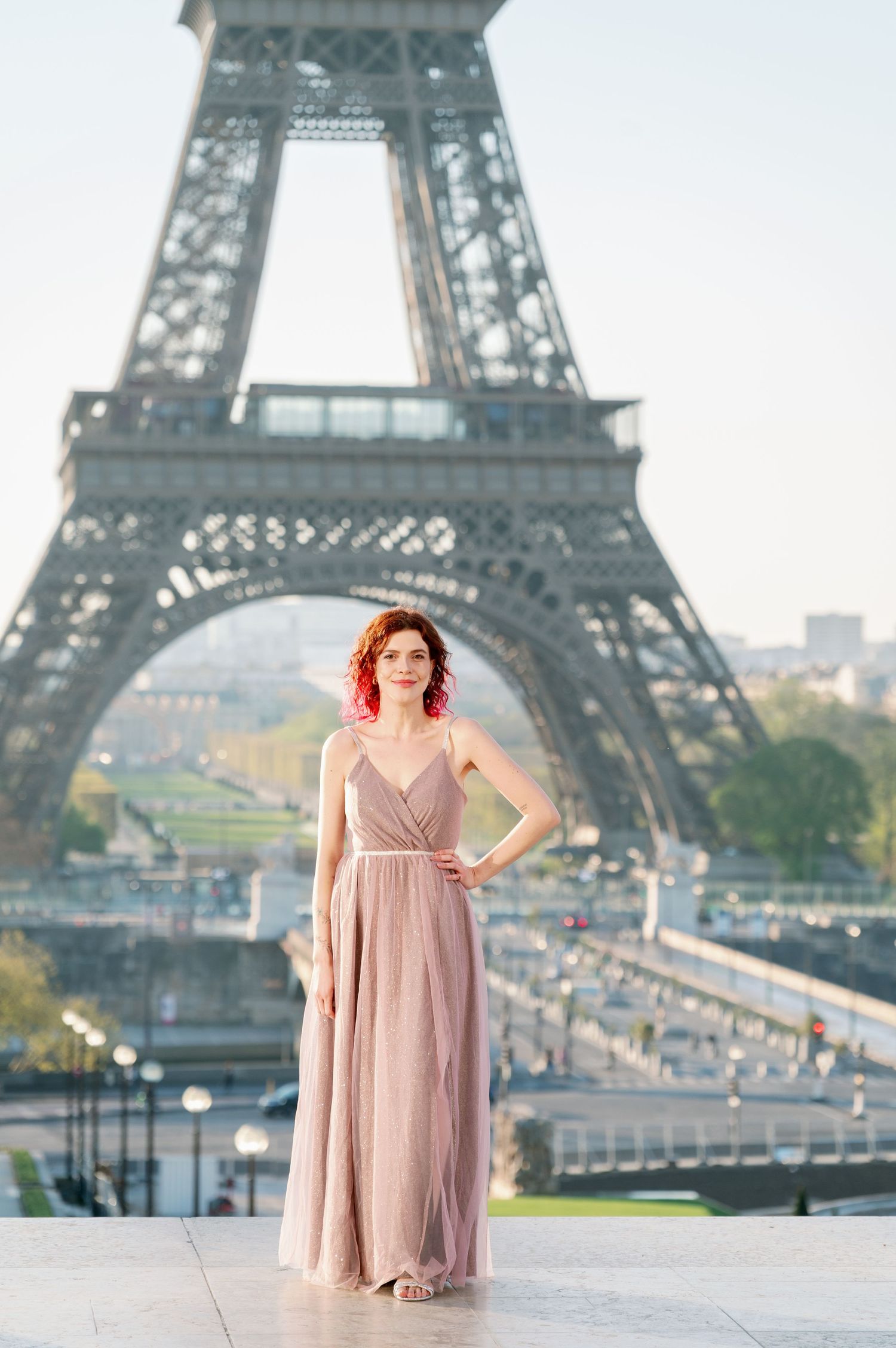 A series of photos showing a person in a pink dress posing in front of the iconic Eiffel Tower in Paris.