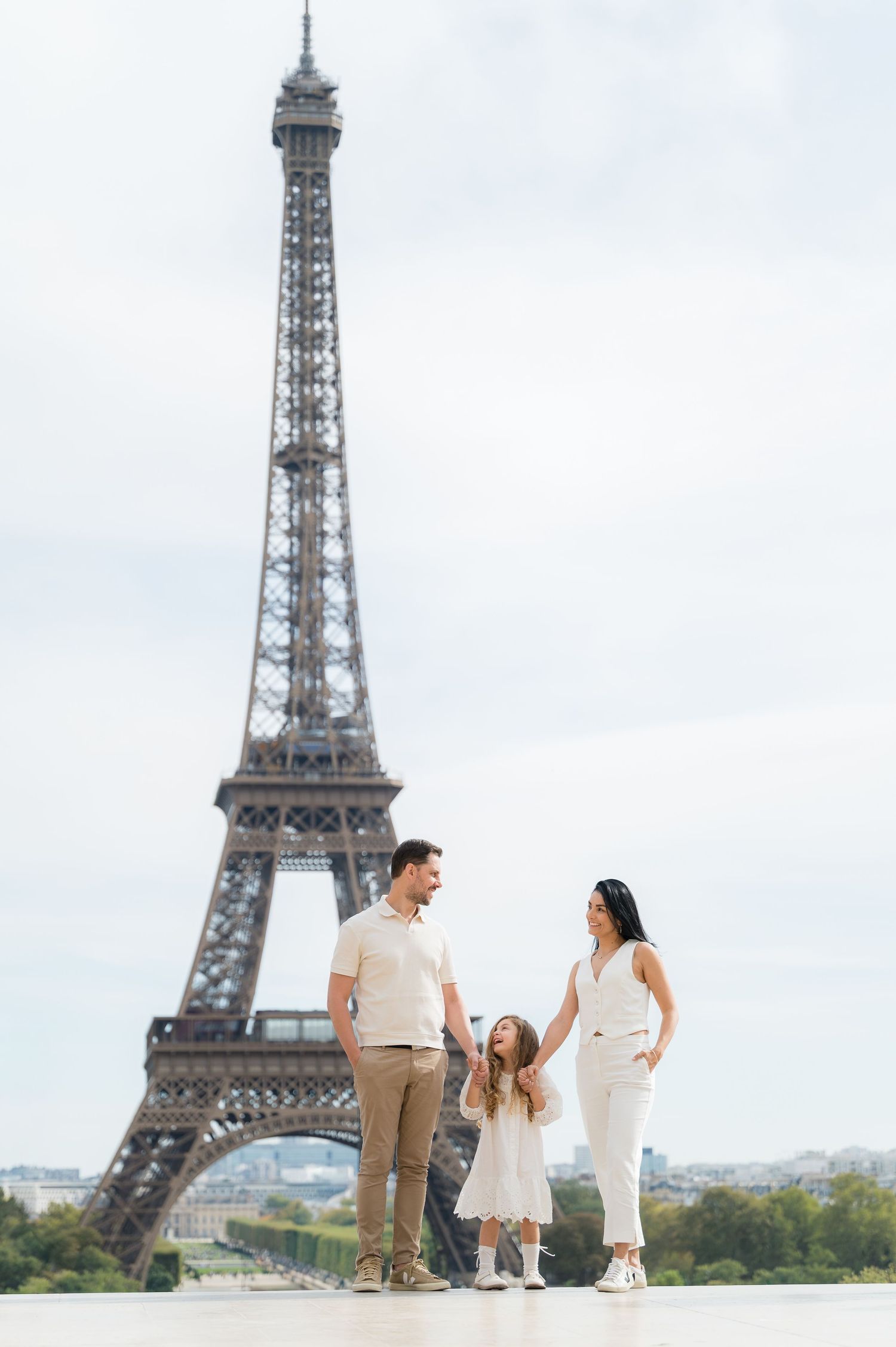 Family enjoying a romantic moment together in front of the iconic Eiffel Tower in Paris, France.