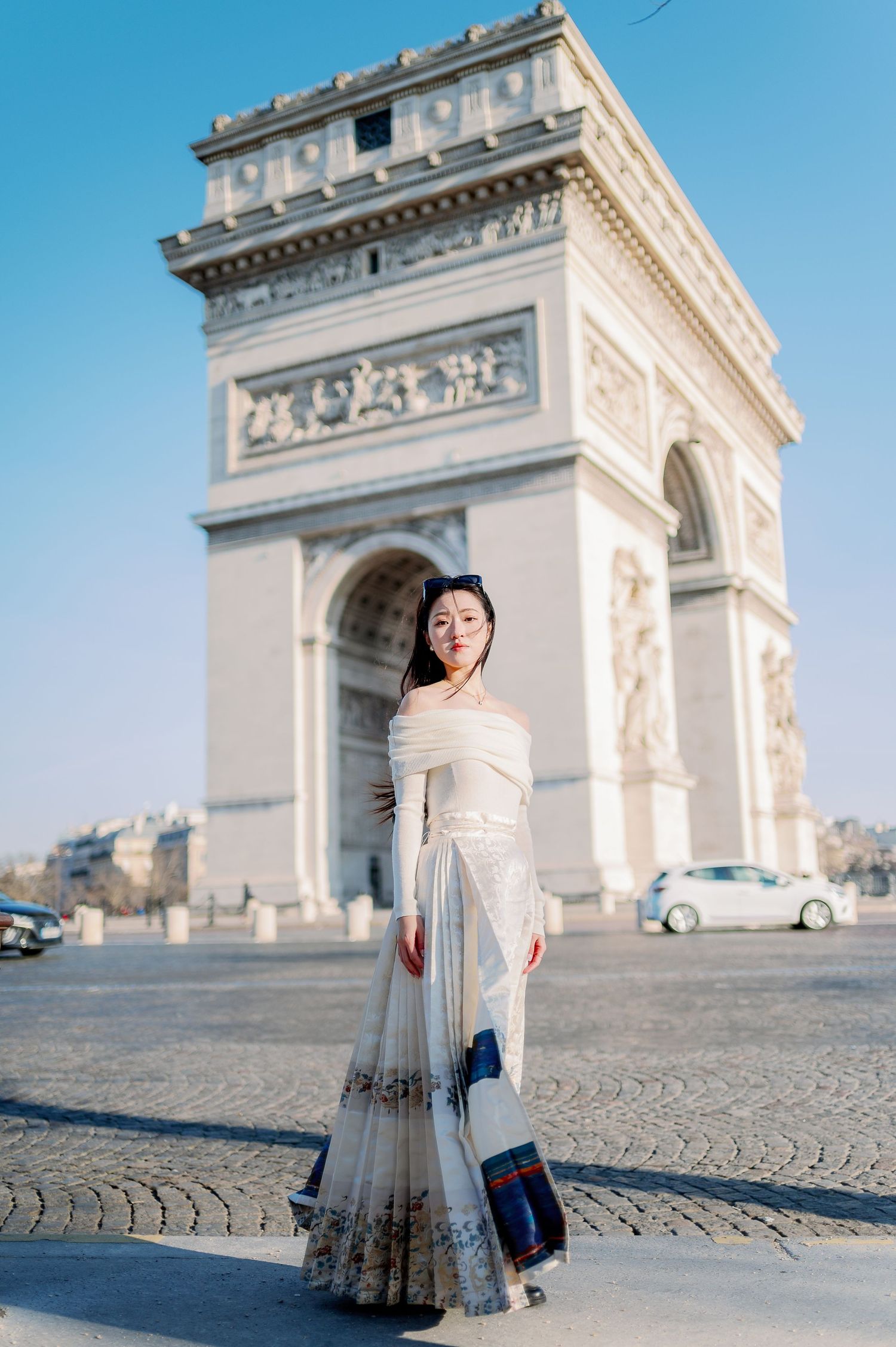 A graceful portrait featuring a long dress against the magnificent Arc de Triomphe in Paris.