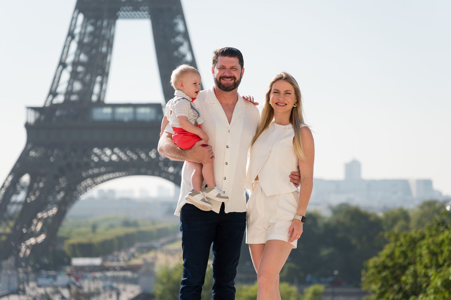 A family enjoying a summer day in front of the iconic Eiffel Tower in Paris, France.
