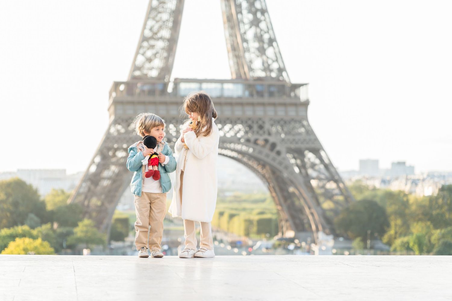 Silhouettes of a group walking together along the Seine River with the Eiffel Tower in golden sunlight.