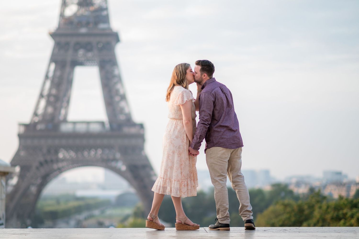 Romantic couple sharing tender moment with Eiffel Tower in background during Paris photoshoot.