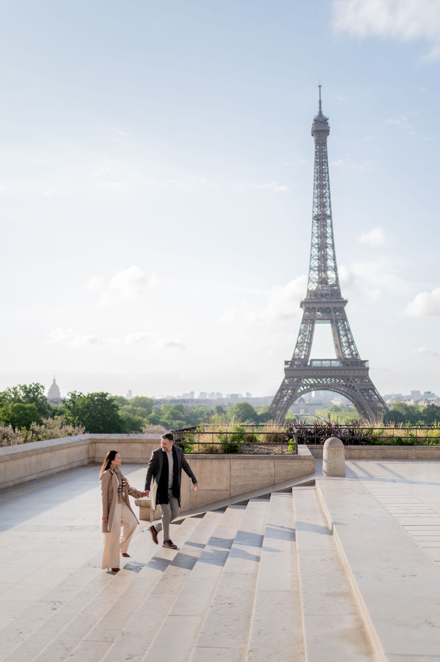 People walking on the steps of Trocadero plaza with the iconic Eiffel Tower visible in the background in Paris.