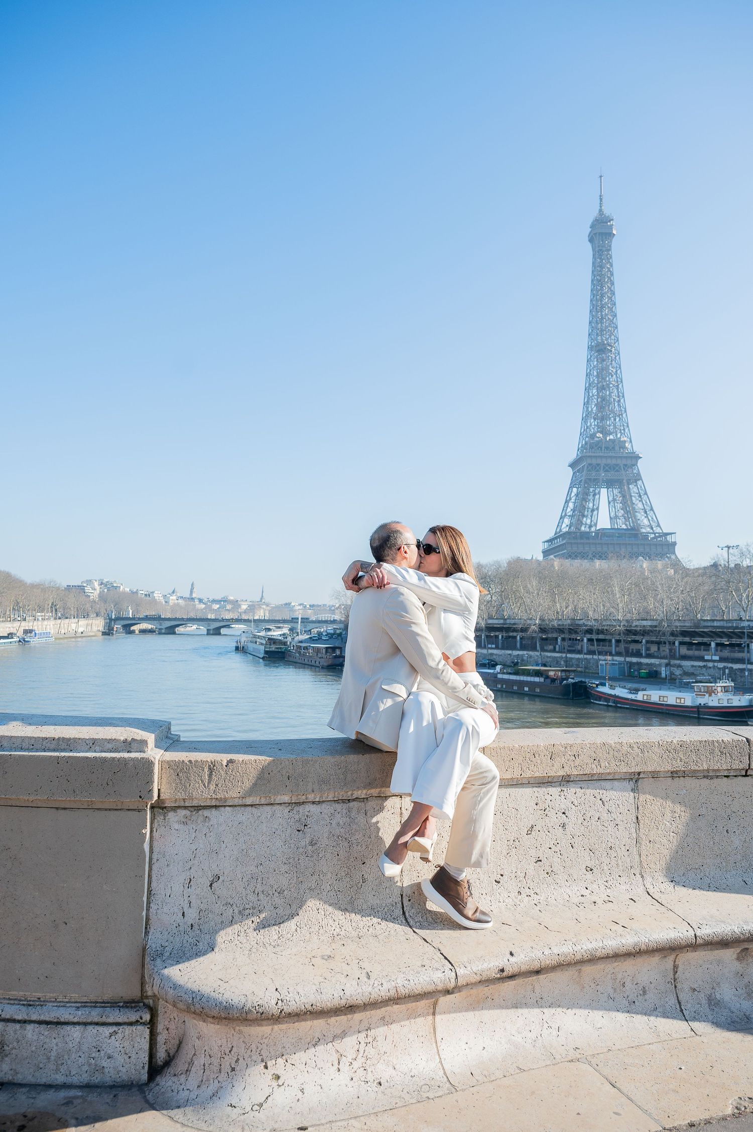 A tender moment shared along the Seine River with the Eiffel Tower standing majestically in the background.