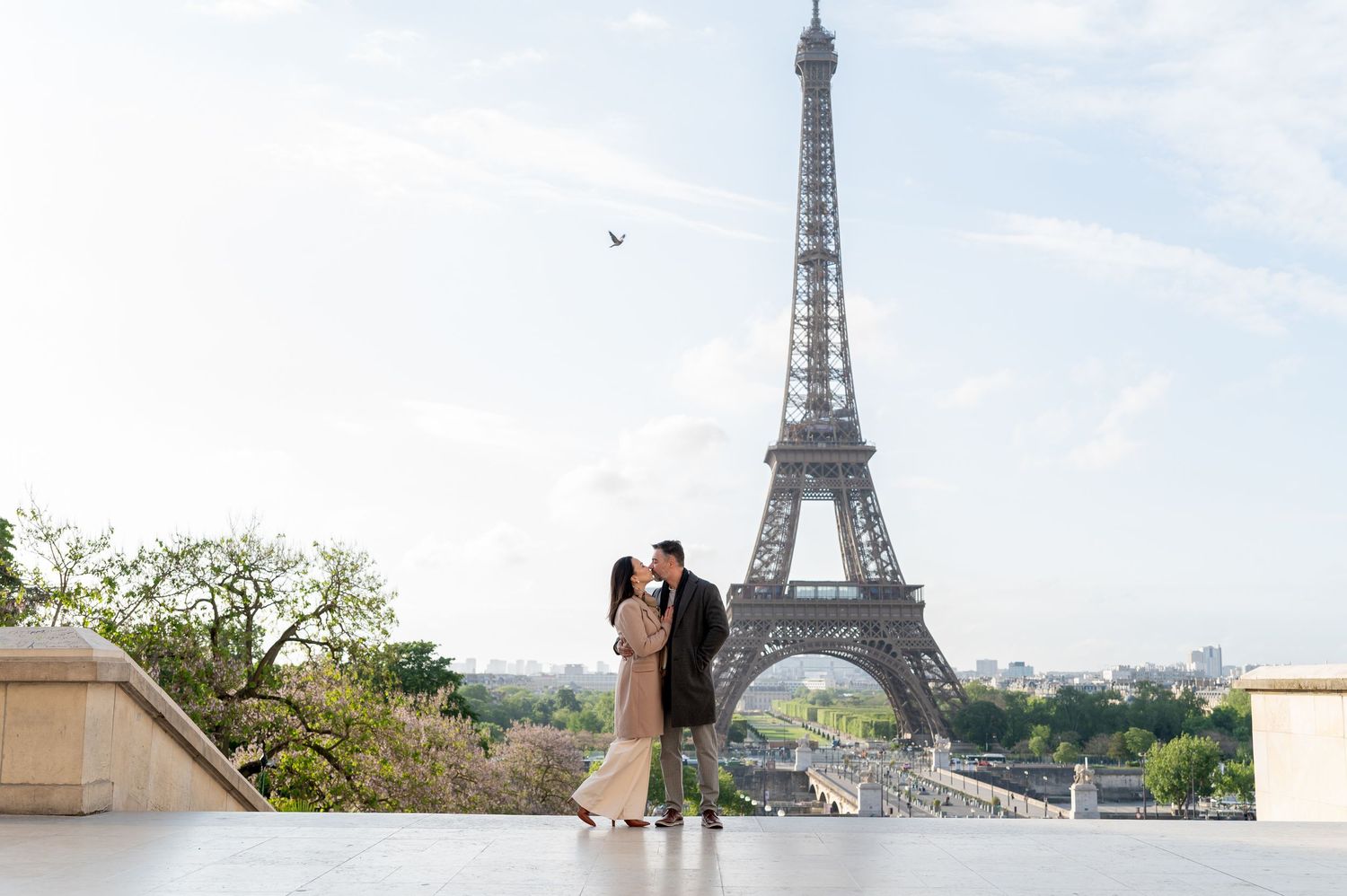 Couple embracing at Trocadero viewpoint with Eiffel Tower in background.