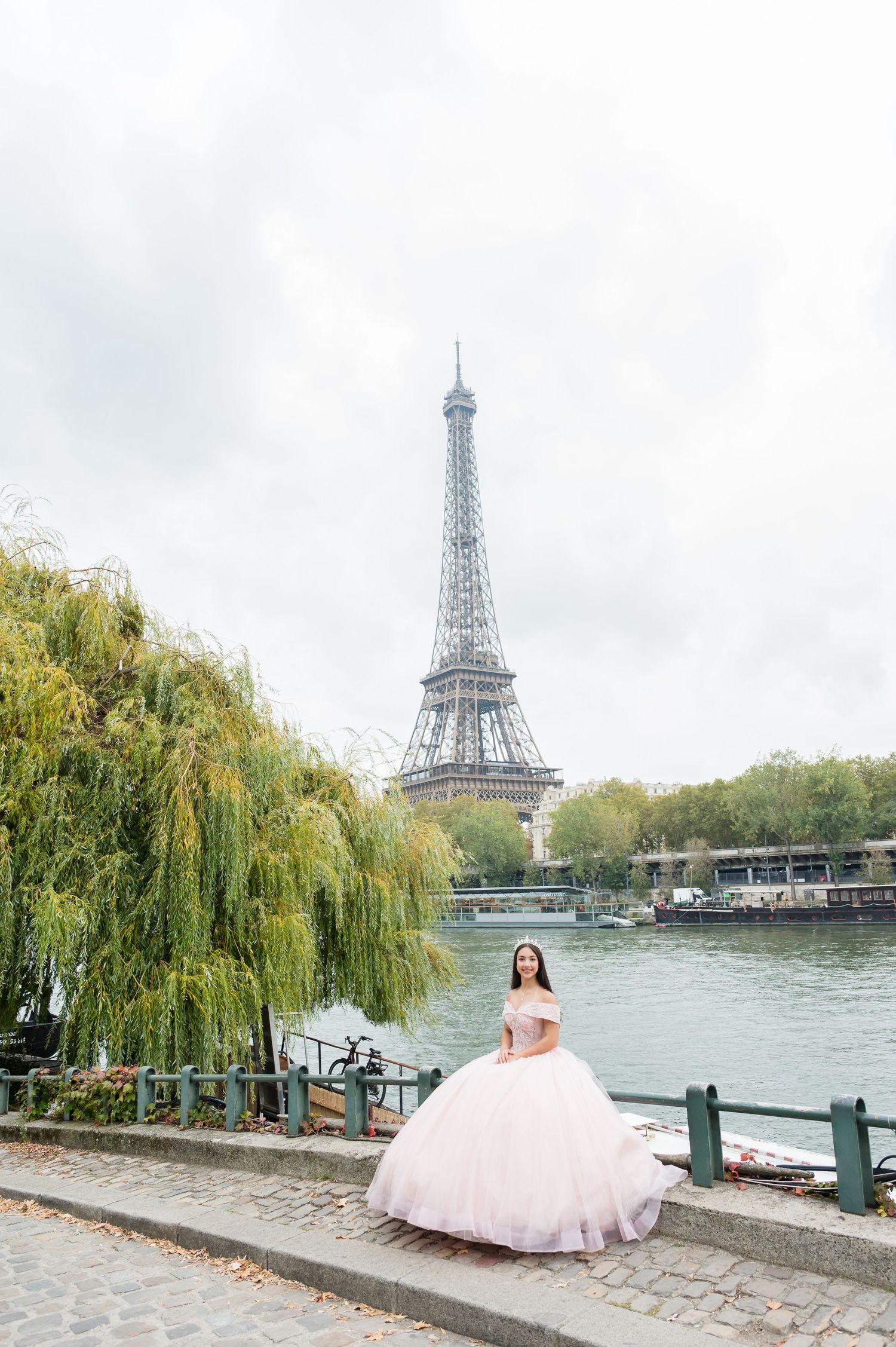 A series of romantic photos featuring a pink ballgown against the backdrop of the Eiffel Tower and Seine River in Paris.