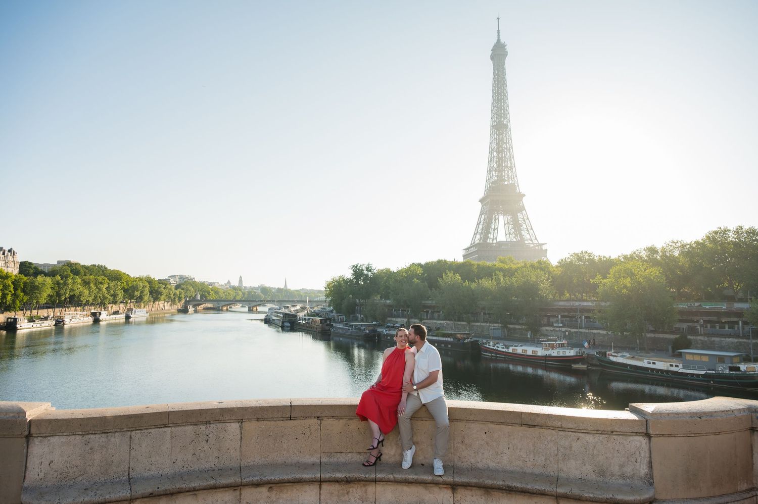 The iconic Eiffel Tower stands tall against a hazy Paris skyline during a scenic summer sunset.