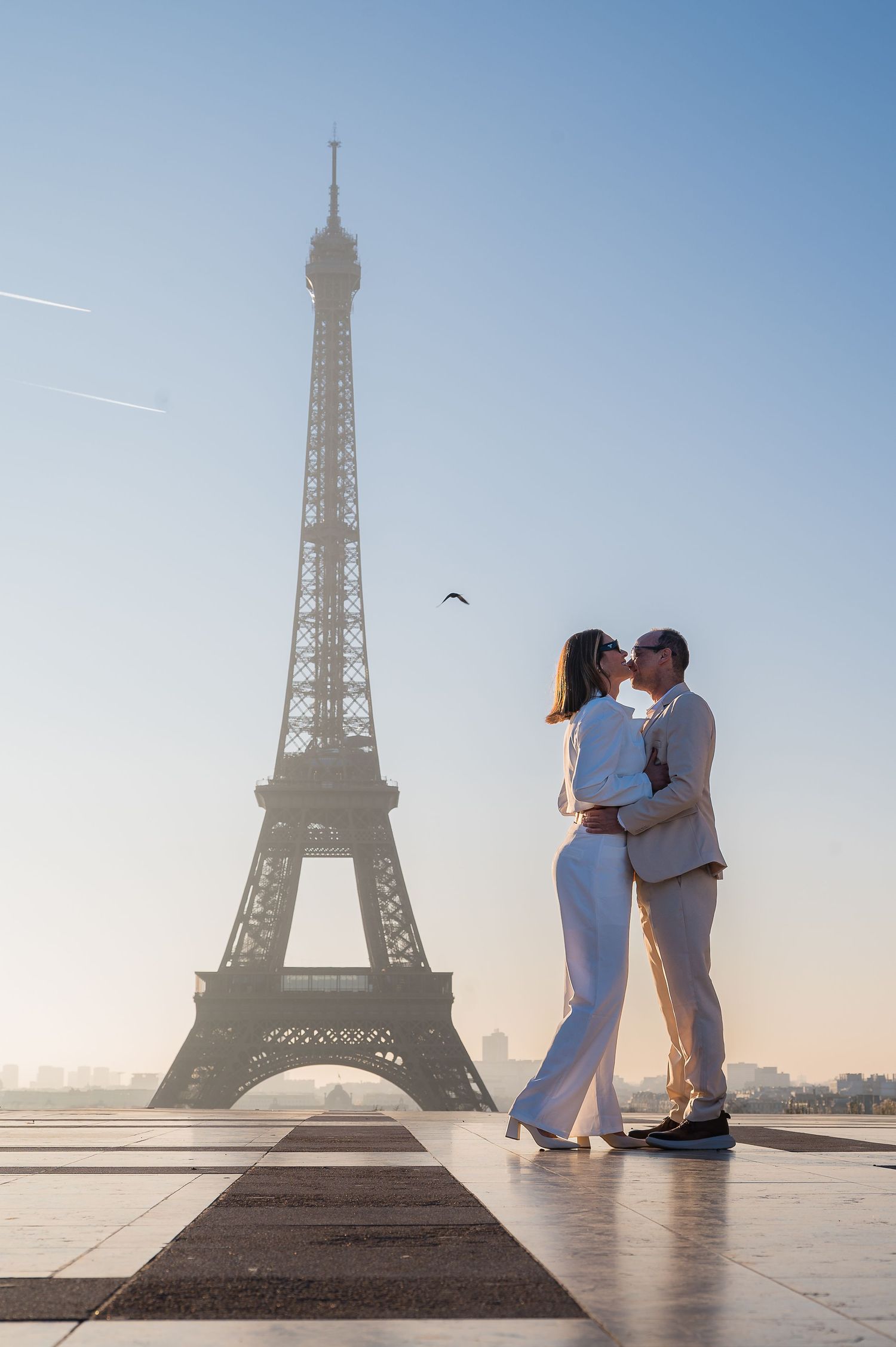 A loving embrace captured in silhouette against the Eiffel Tower during a beautiful Paris morning.