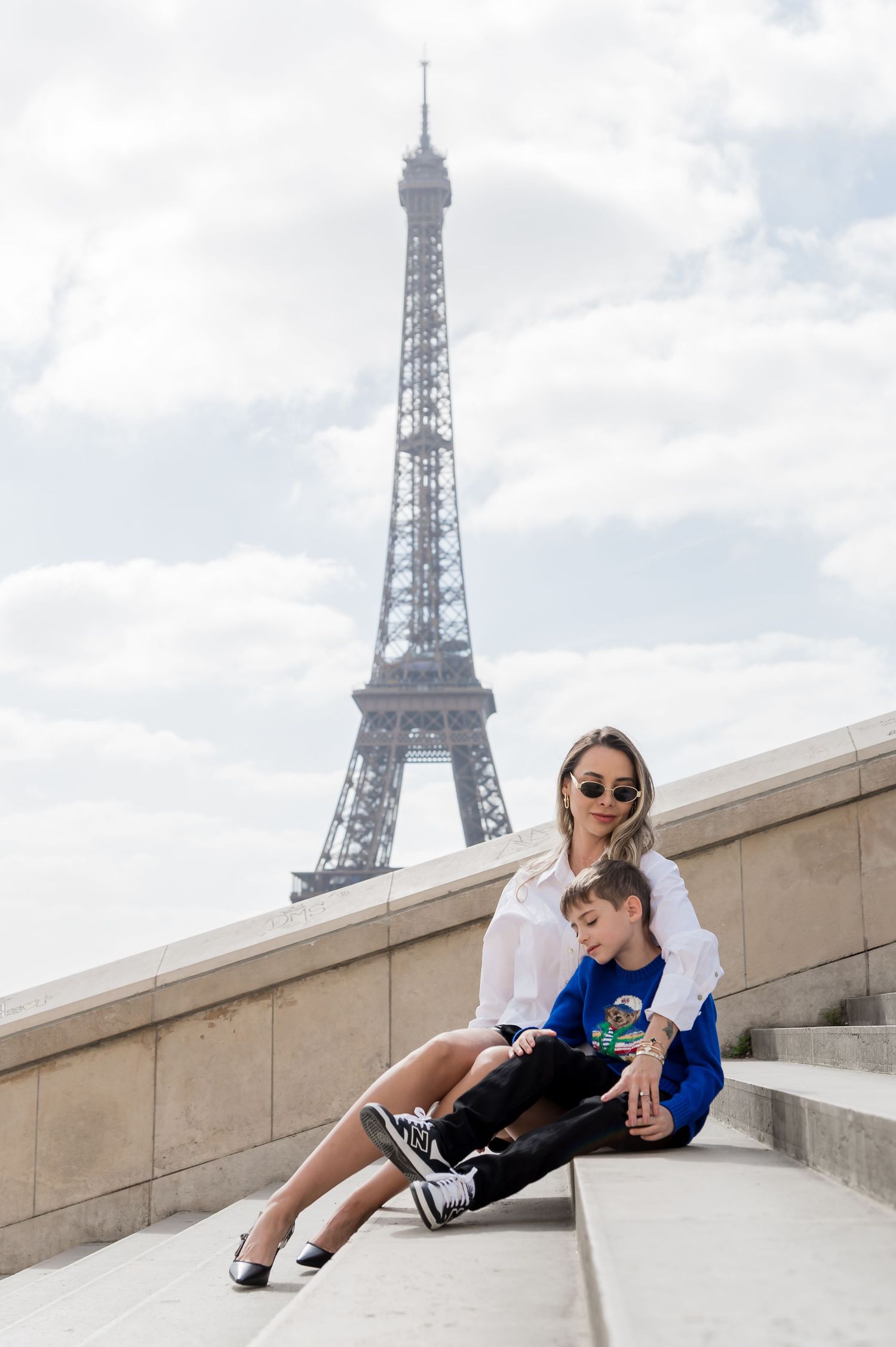 A photo series showing a person relaxing and posing on steps near the Eiffel Tower in Paris.