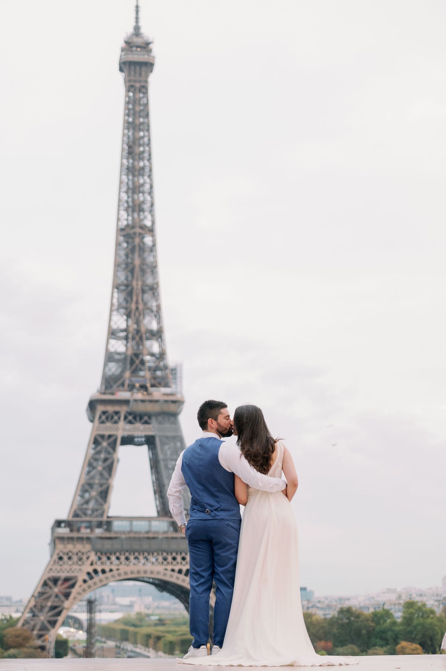 A couple shares romantic moments in front of the iconic Eiffel Tower in Paris across multiple photos.
