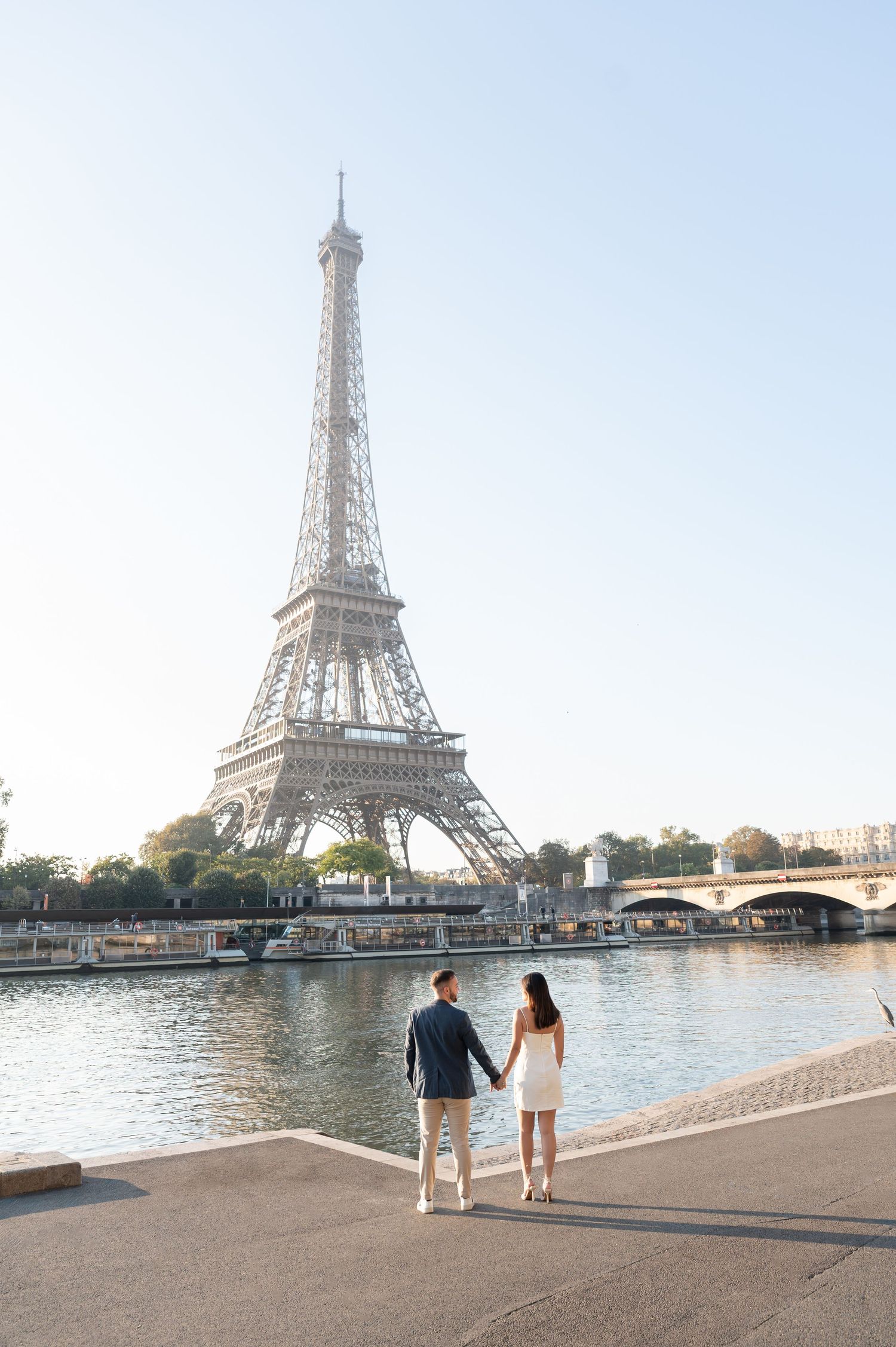 Four connected photos show people walking along the Seine River with the iconic Eiffel Tower visible in Paris, France.