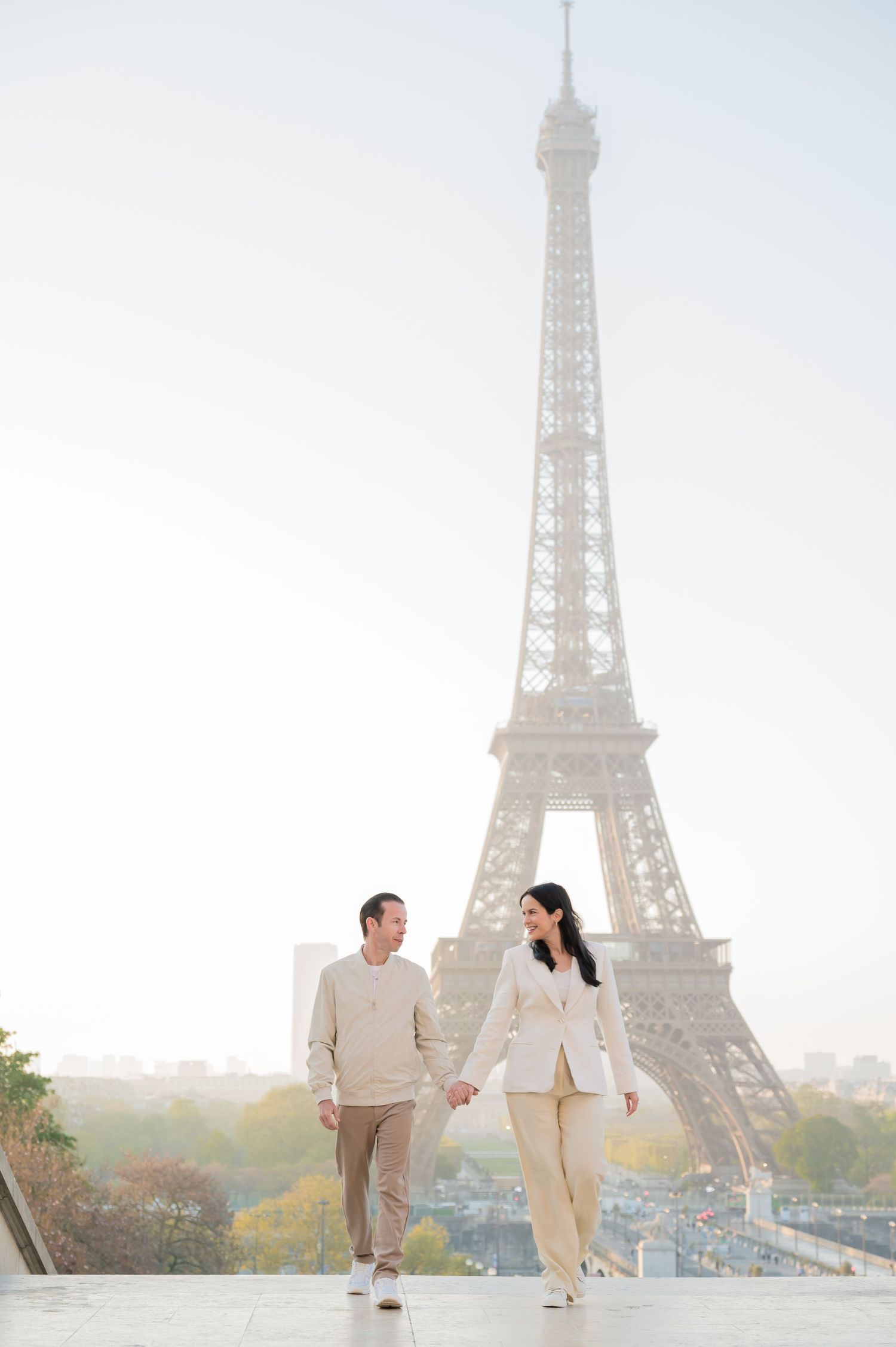 Romantic couple strolls along Seine River path with misty Eiffel Tower views in three connected photos, Paris.