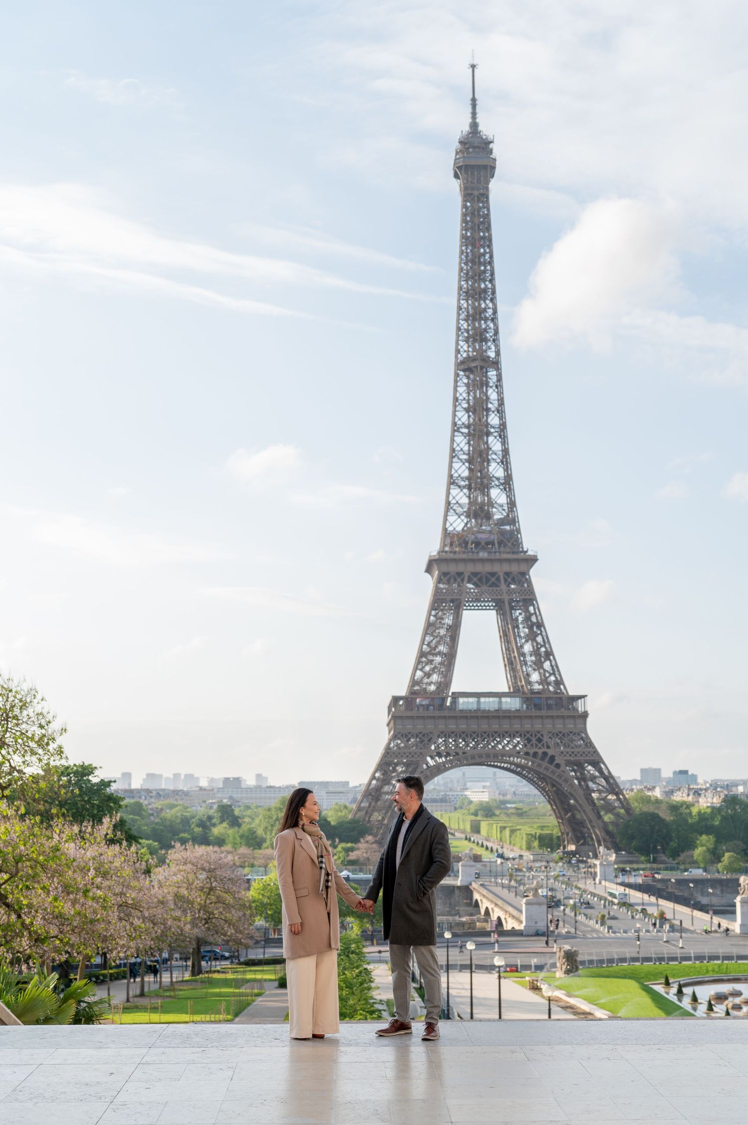 A couple shares a romantic moment at the Trocadero viewing platform with the Eiffel Tower as their backdrop in Paris.
