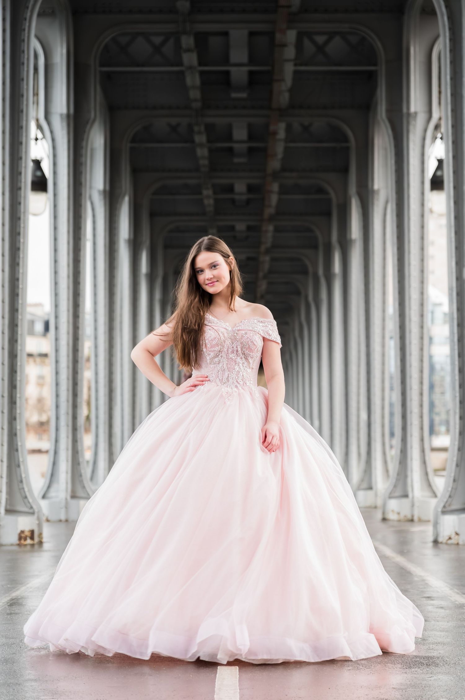 A stunning pink ball gown with beaded bodice and full tulle skirt photographed under an architectural colonnade.