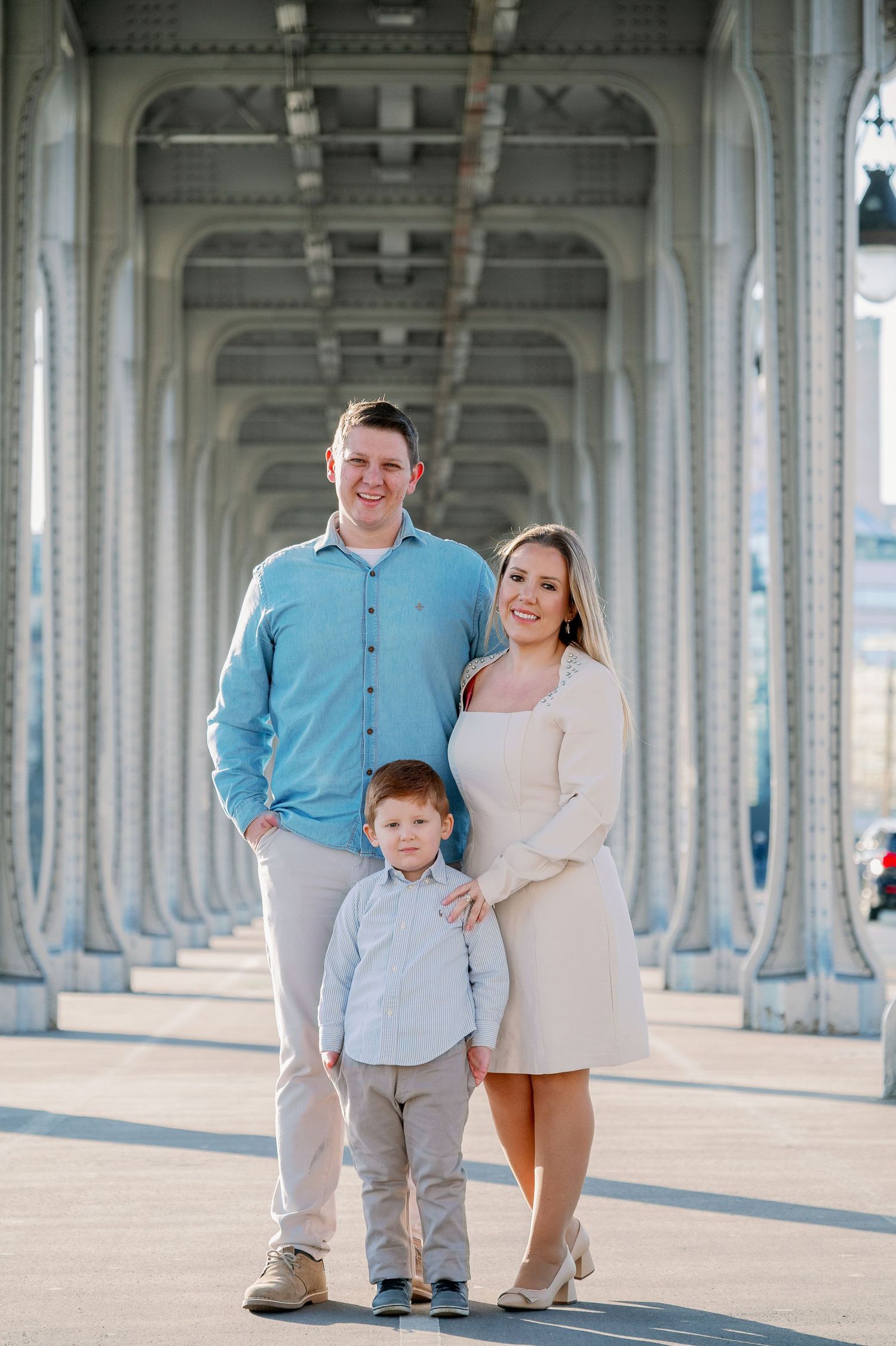 A family poses under an architectural archway in formal attire.