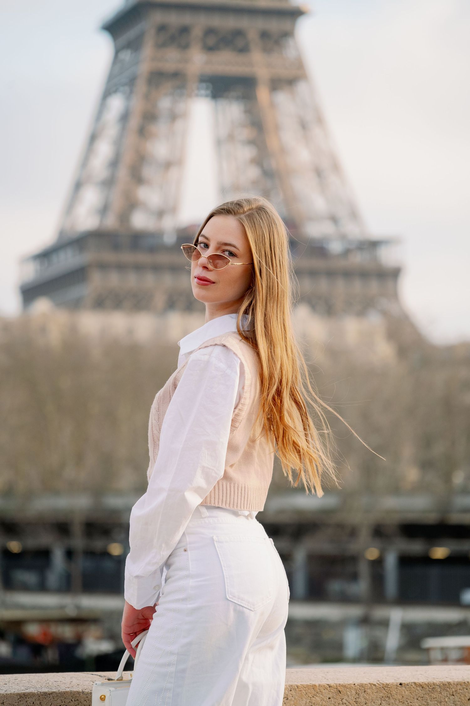 Fashion portrait with Eiffel Tower backdrop featuring all-white ensemble.