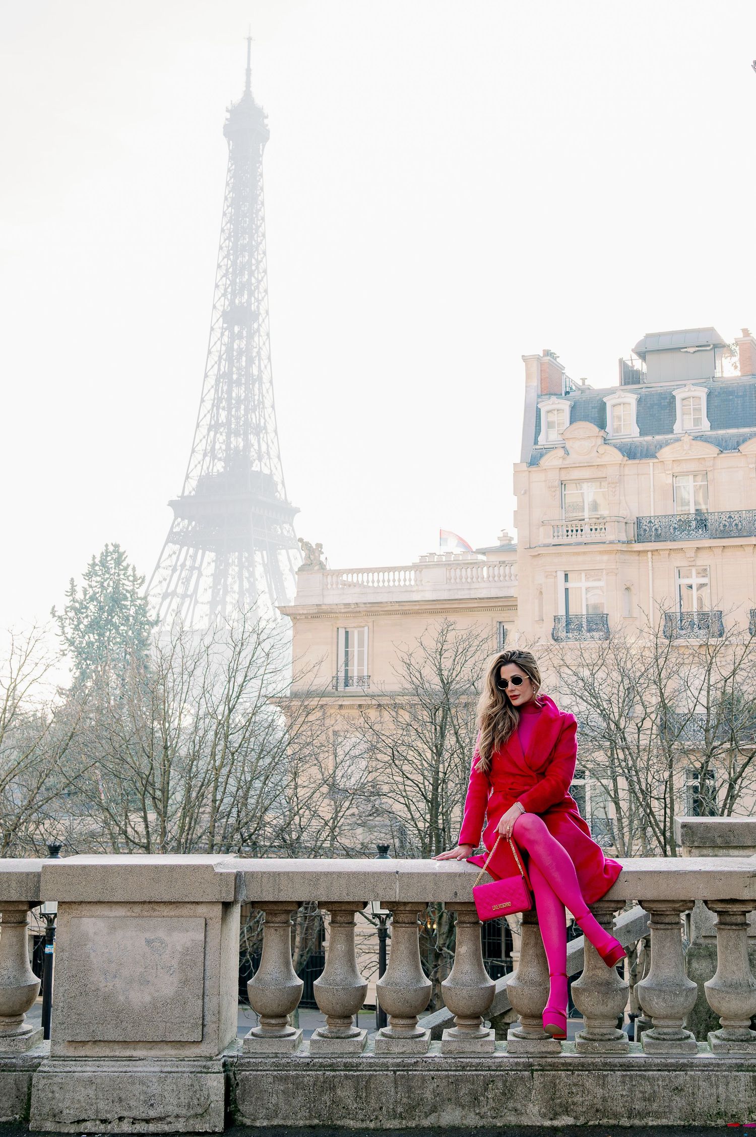 Stylish red monochrome outfit photographed near the Eiffel Tower in Paris.