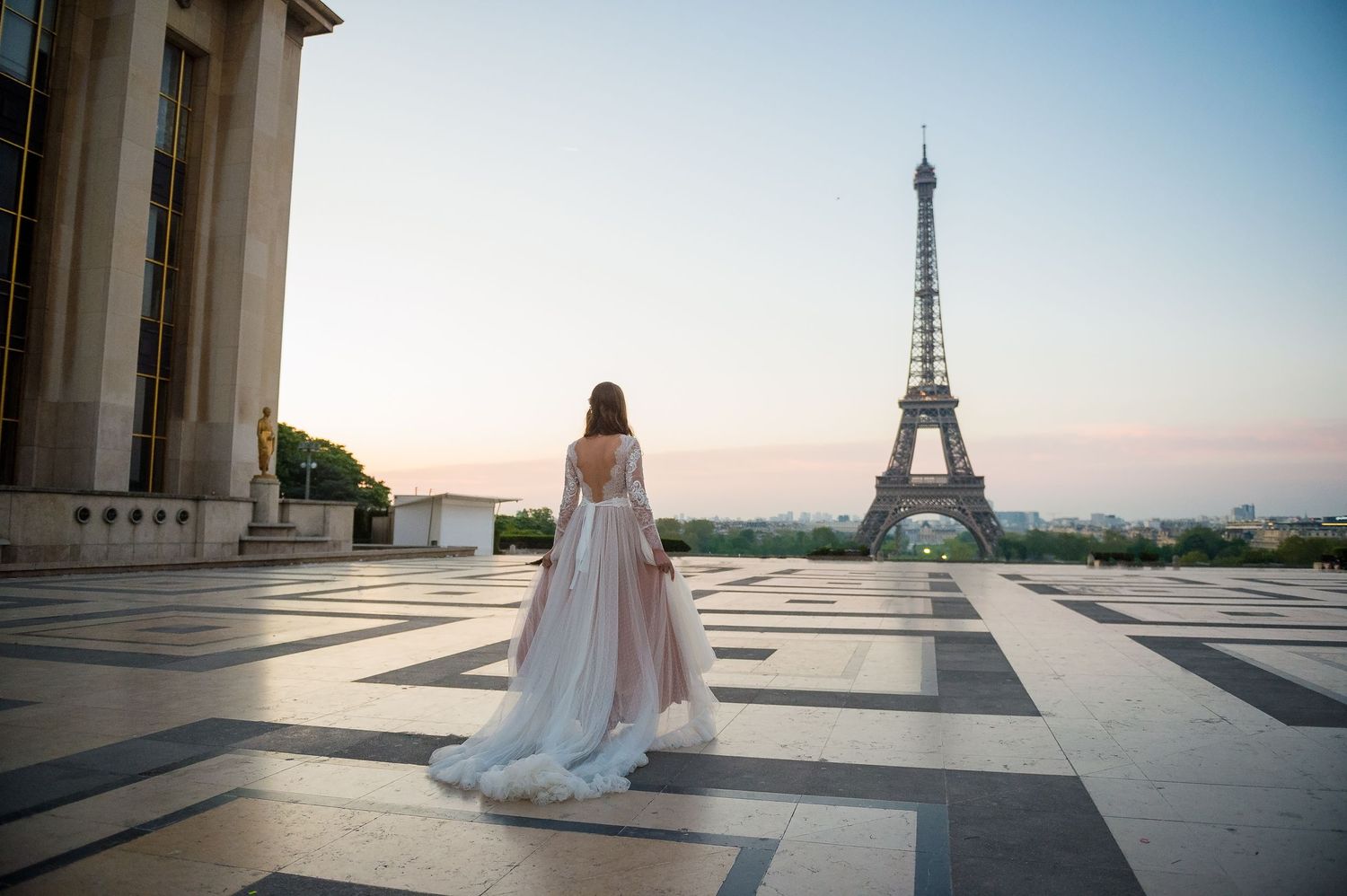 Bride in flowing dress admiring Eiffel Tower view from Trocadero.