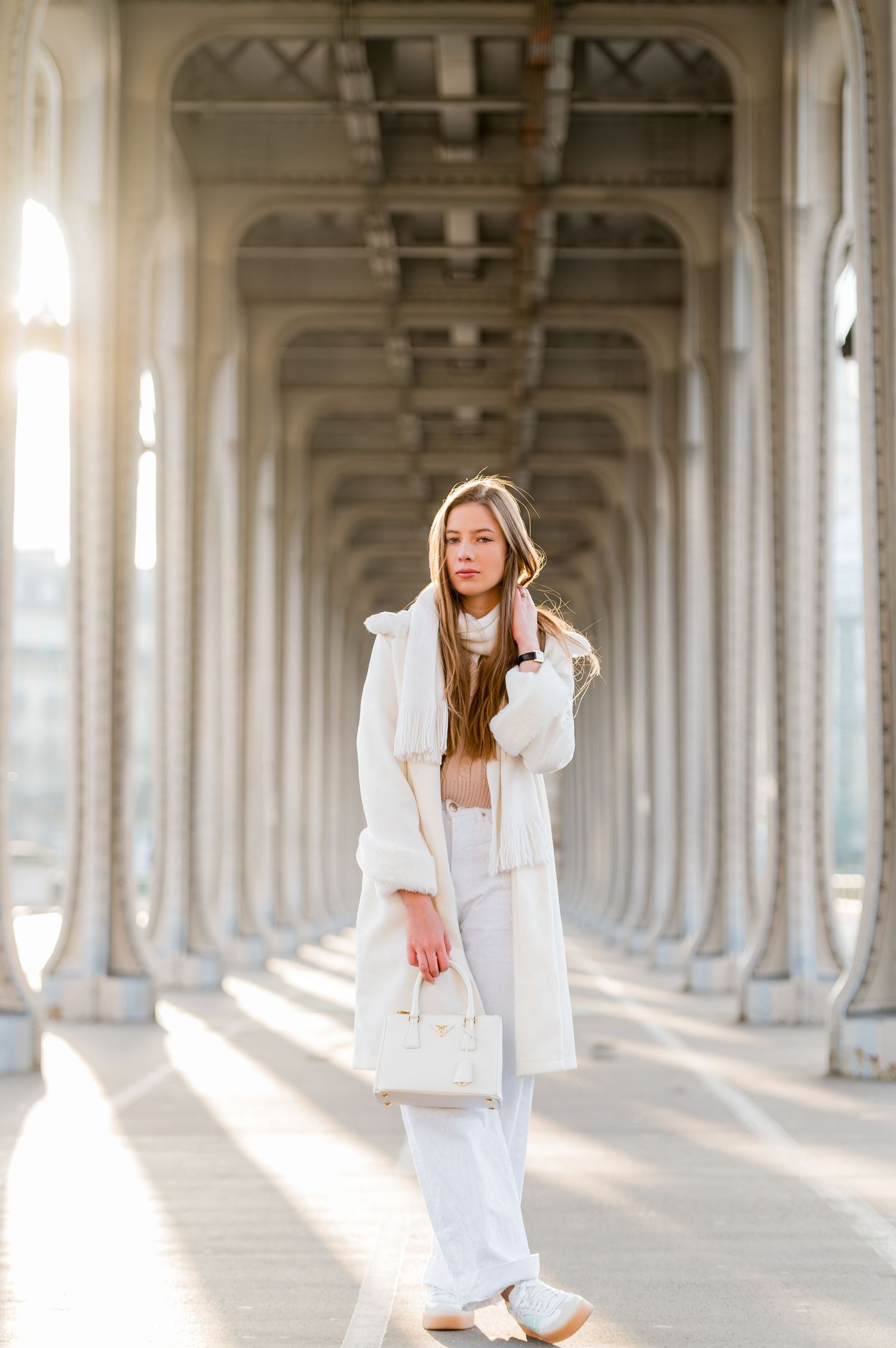 Fashion photography under archways featuring monochromatic white winter outfit.