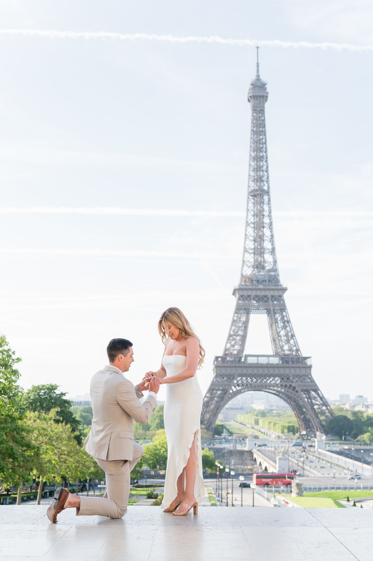 Man proposing to woman on one knee in front of the Eiffel Tower in Paris, France.