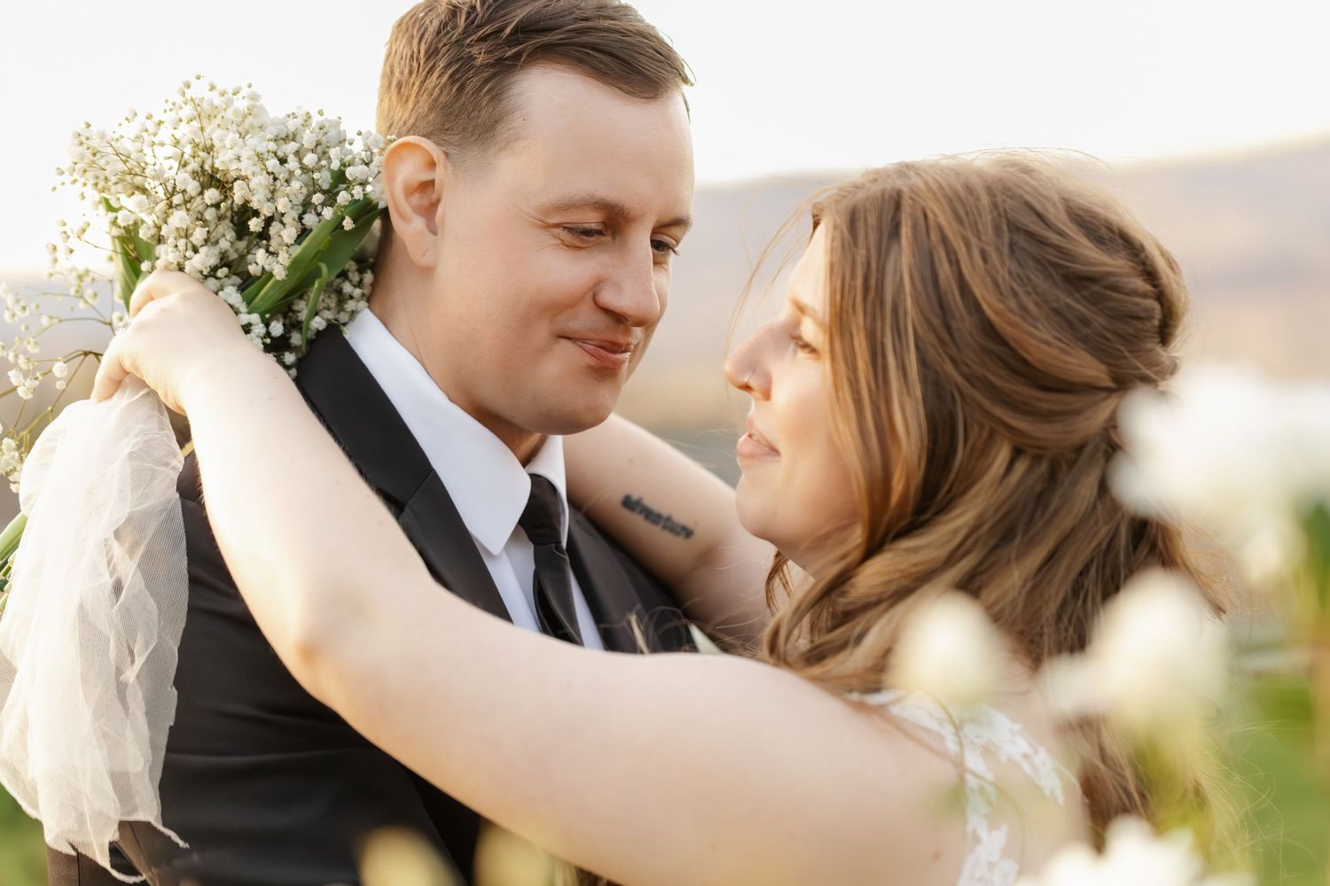 A romantic wedding couple shares tender moments in a series of intimate outdoor portraits at sunset.