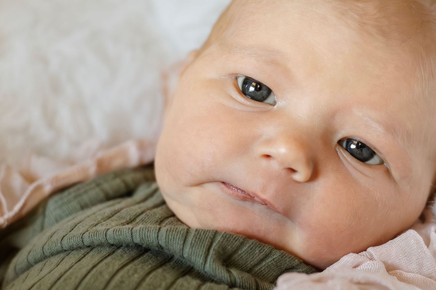 Close-up black and white portrait of a sleeping newborn baby's delicate features.