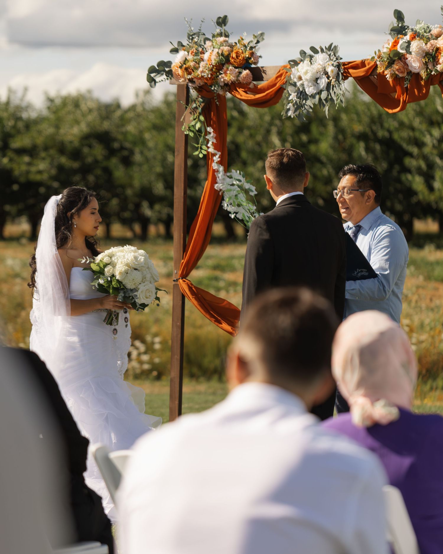 A series of wedding ceremony photos showing a couple exchanging vows under a rustic wooden arch decorated with flowers.