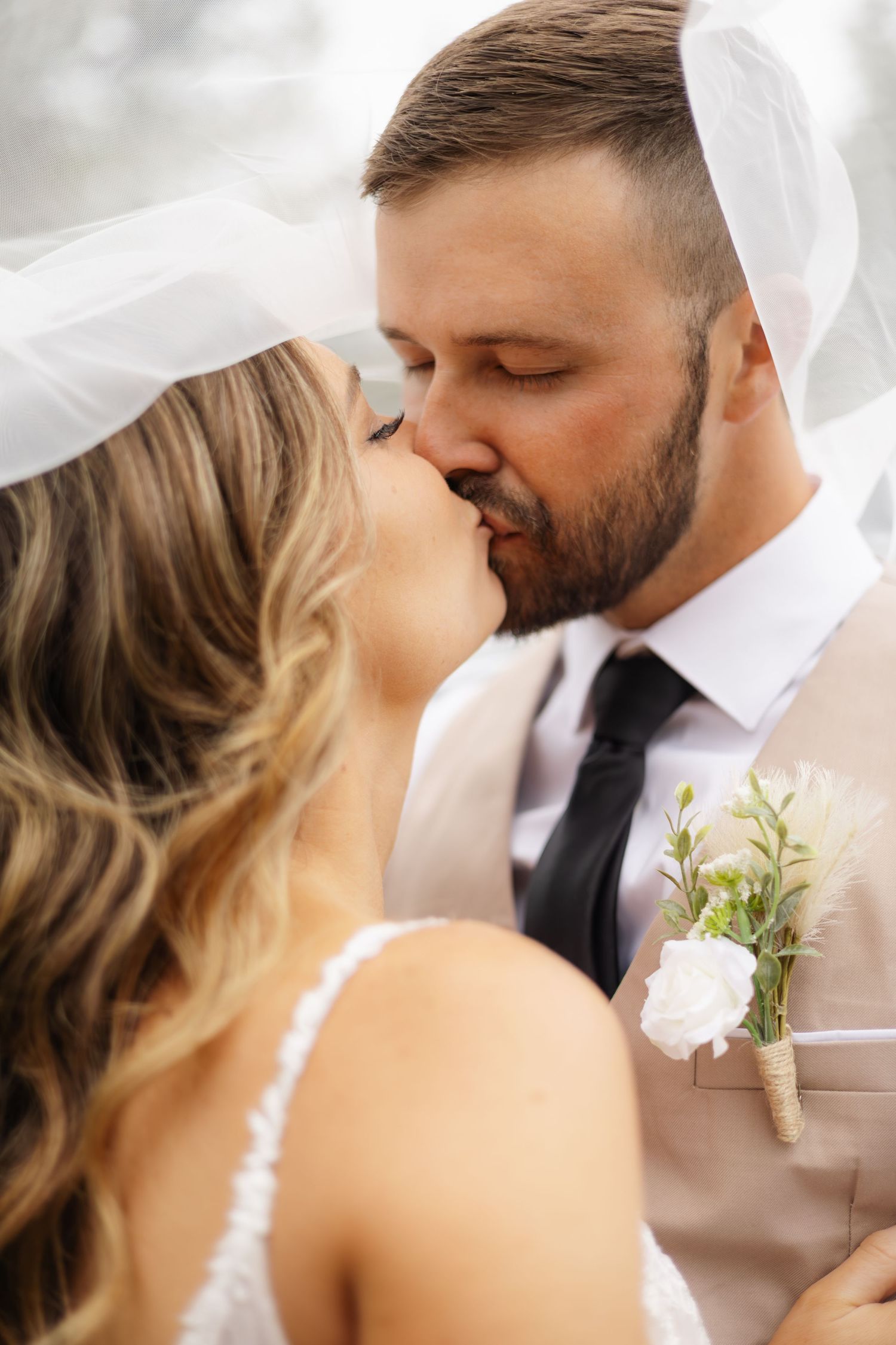 A series of intimate wedding portraits showing tender moments between newlyweds with soft white fabric in the background.
