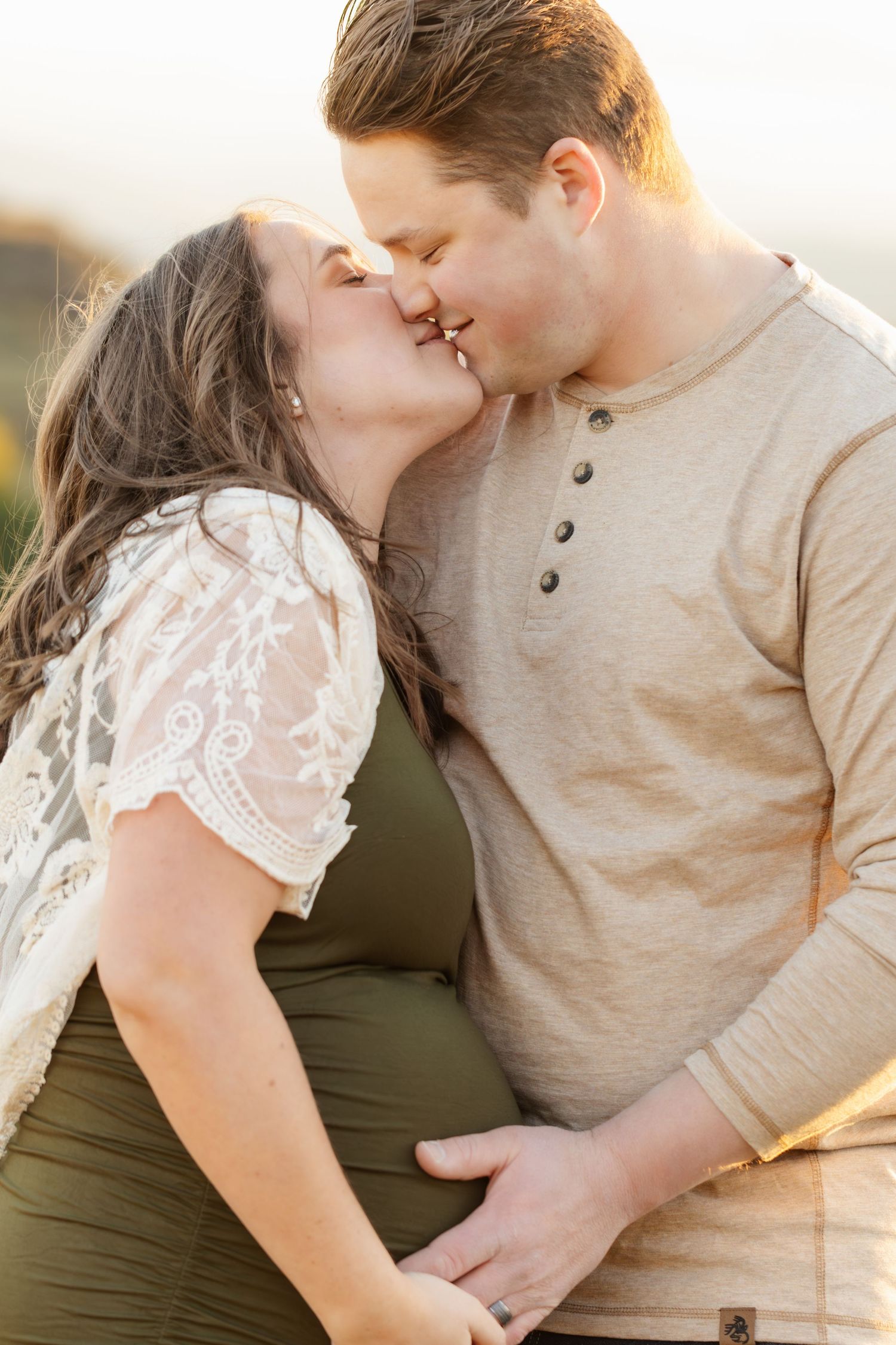 An intimate maternity portrait session showing tender moments between a couple.