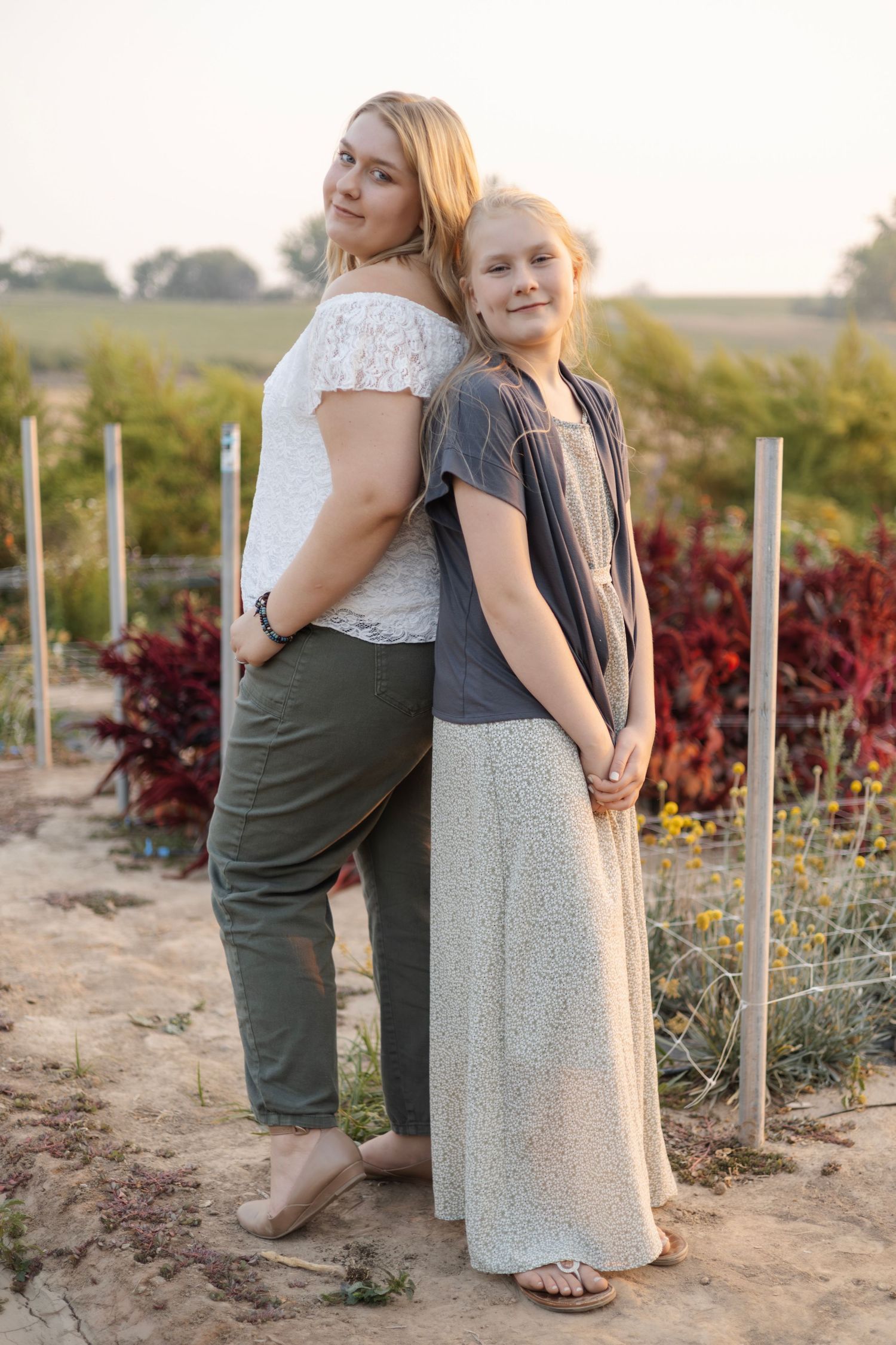 Friends embracing in garden setting during golden hour.