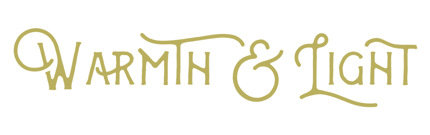 Elegant calligraphy text reading 'Warmth & Light' in gold metallic ink.