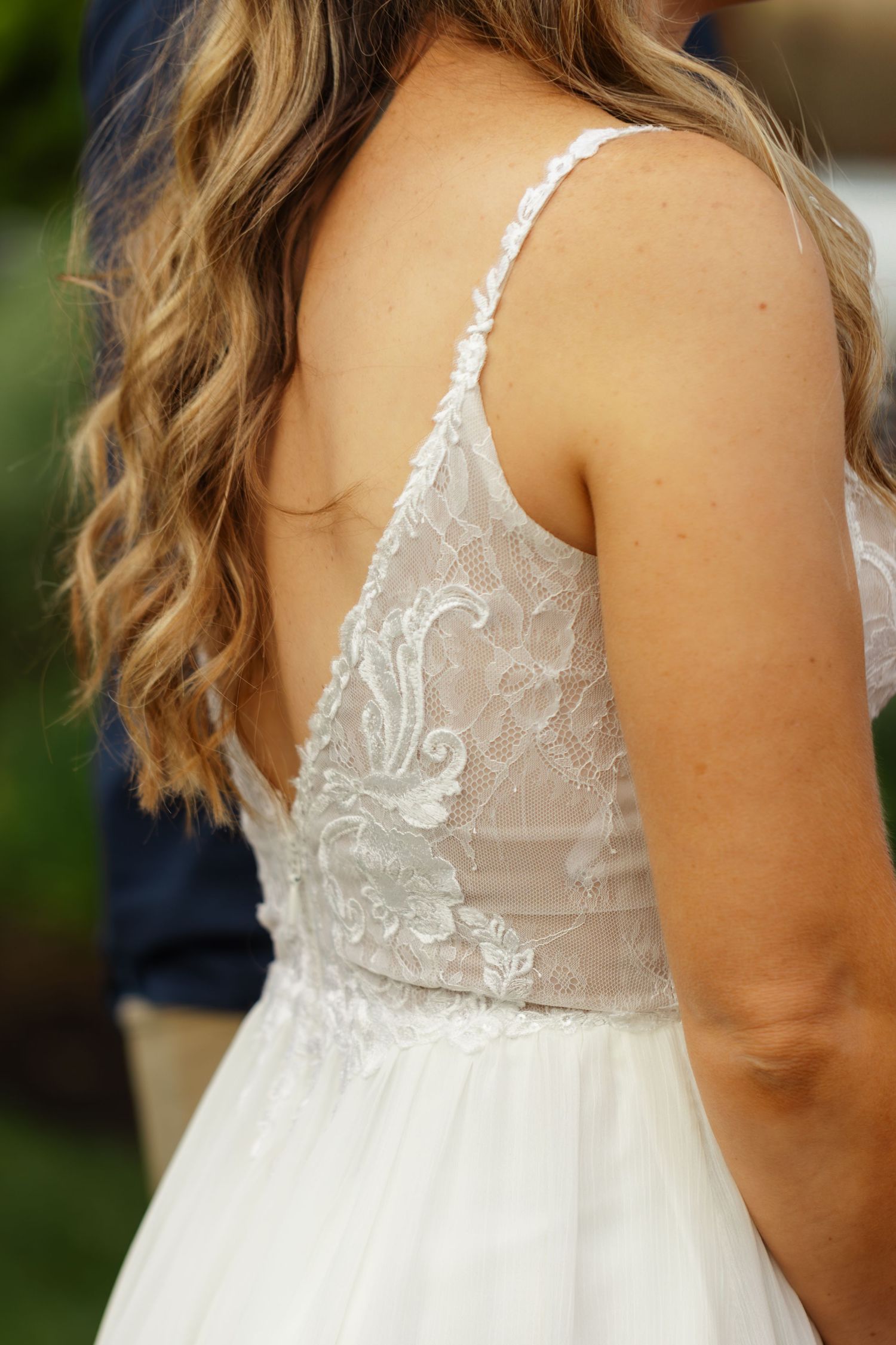 Close-up details of delicate white lace and sheer fabric on a wedding dress bodice from multiple angles.