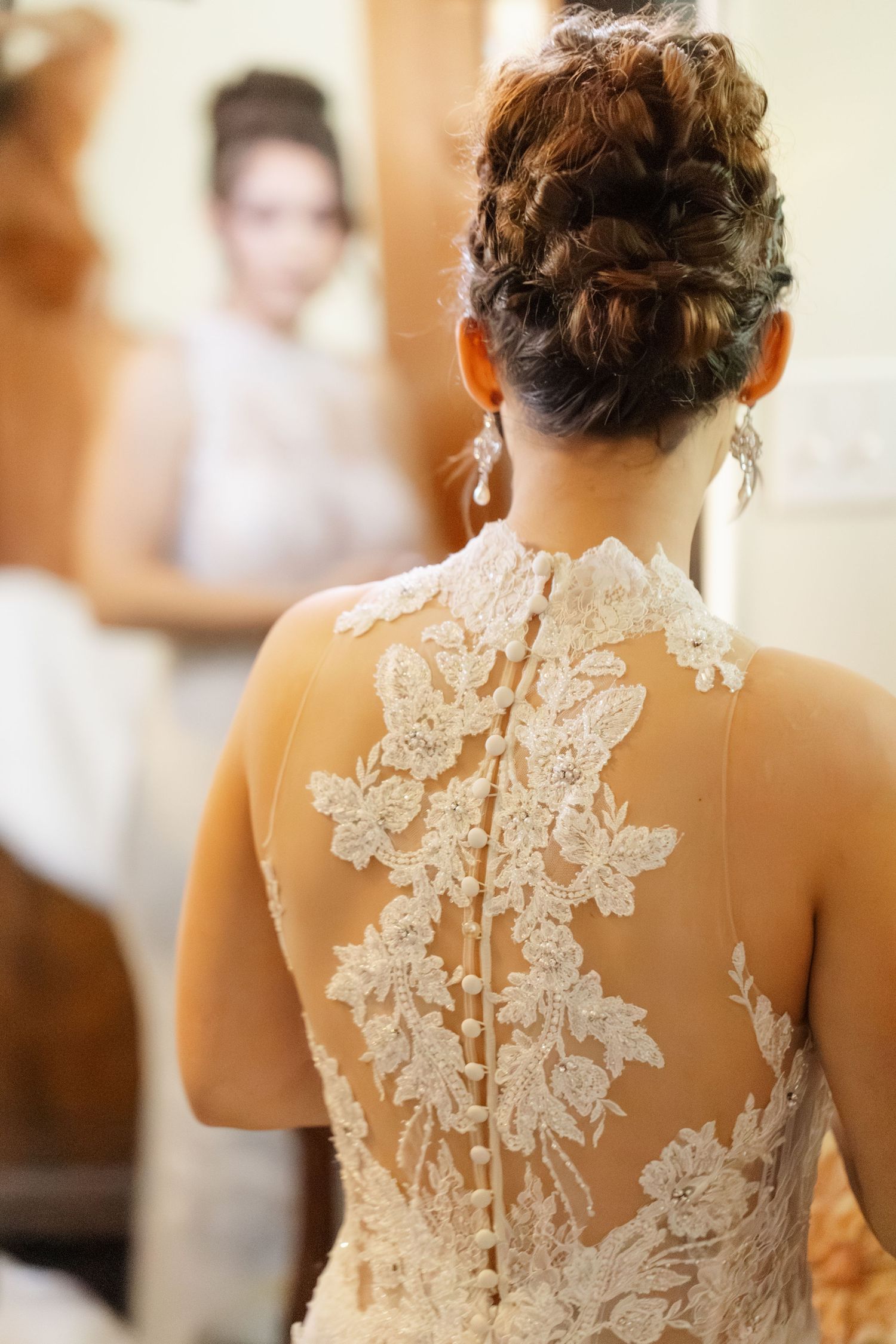 Close-up view of an elegant lace wedding dress back with intricate floral appliques and sheer details.
