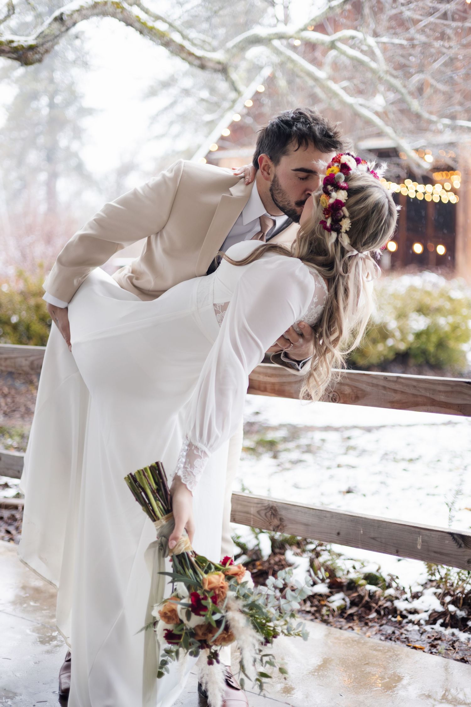 Dramatic dip pose in winter setting with rustic barn and snow in background.