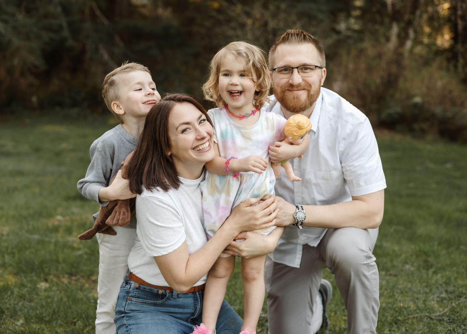 Family shares joyful moments together while playing outdoors on green grass.