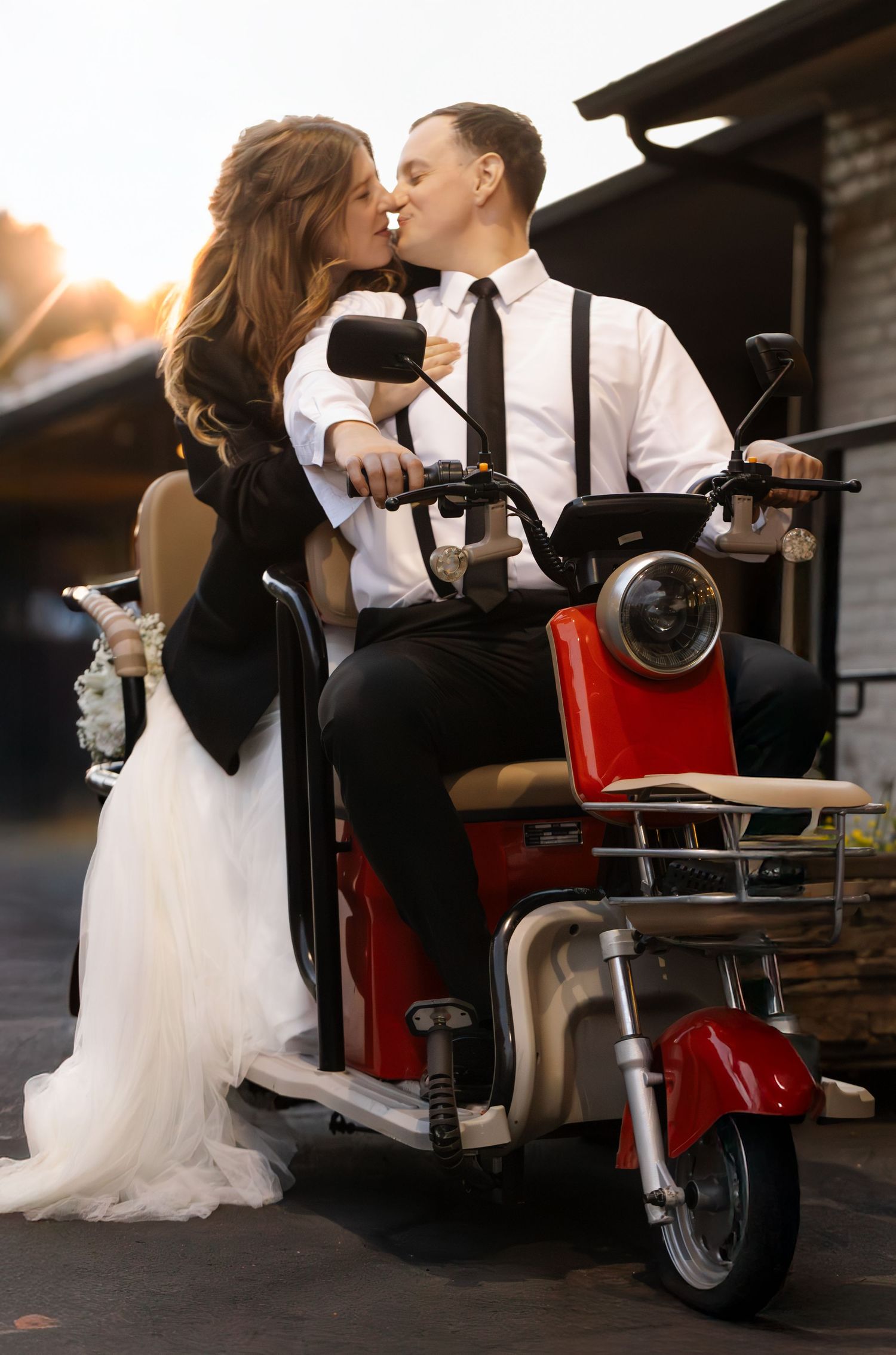 Bride and groom share intimate moments on a vintage red barber chair during sunset wedding photos.