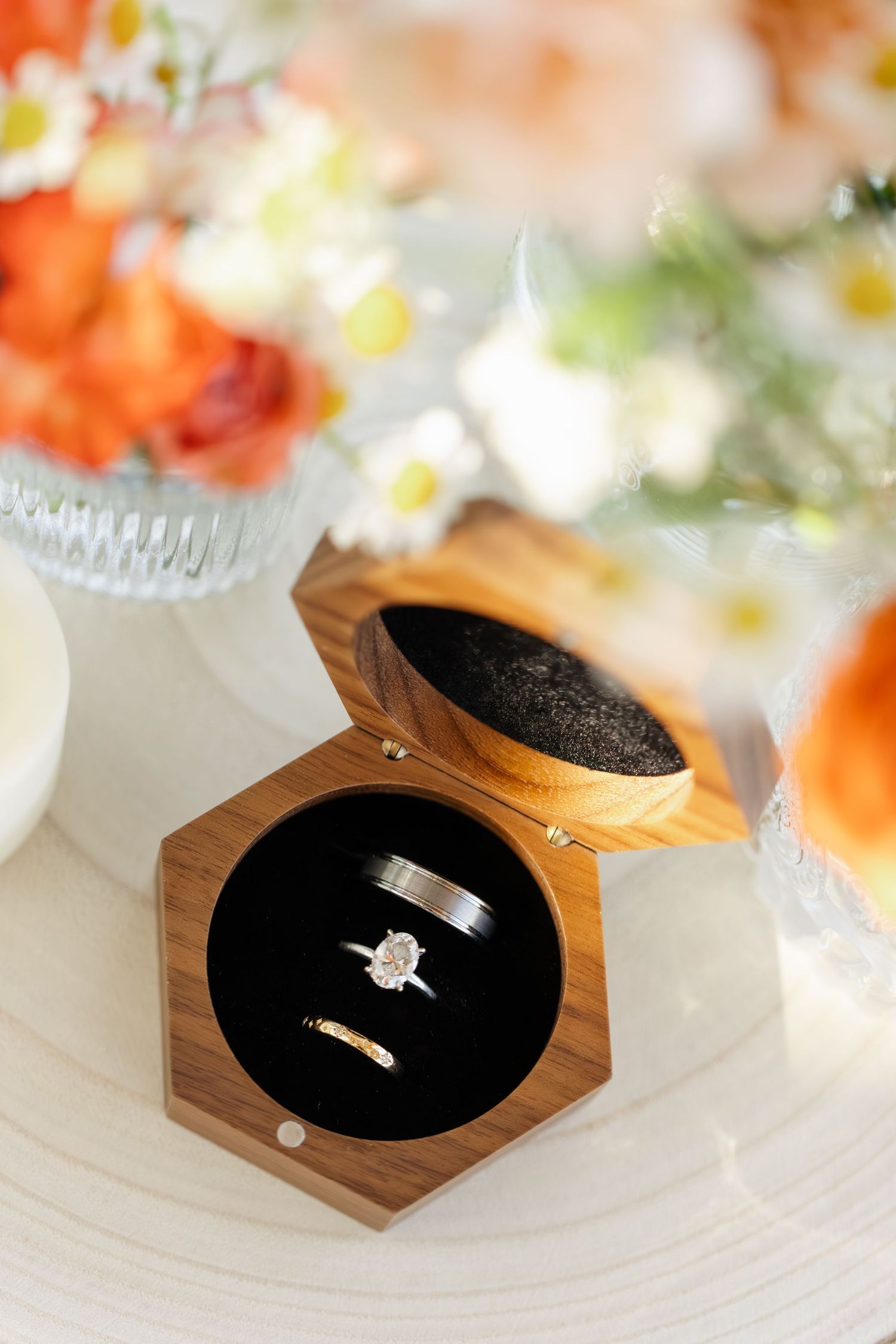 Wedding rings displayed in wooden ring boxes with black velvet interior.
