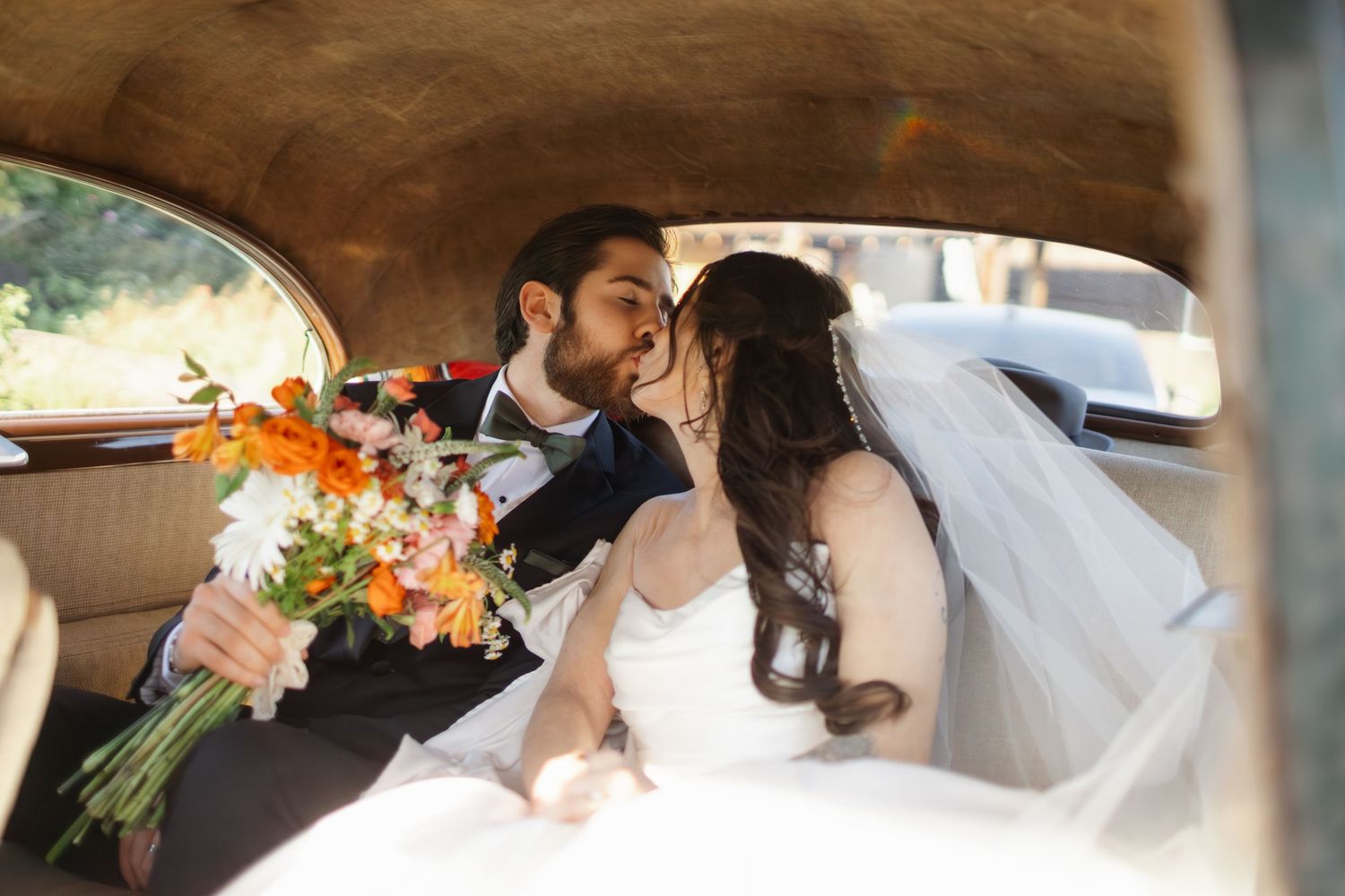 Wedding ceremony moments captured under a rustic wooden arch with autumn flowers.