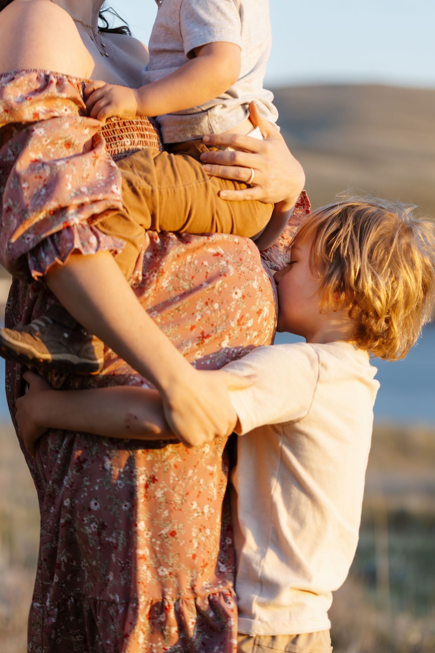 Tender family moment captured during sunset maternity photoshoot.