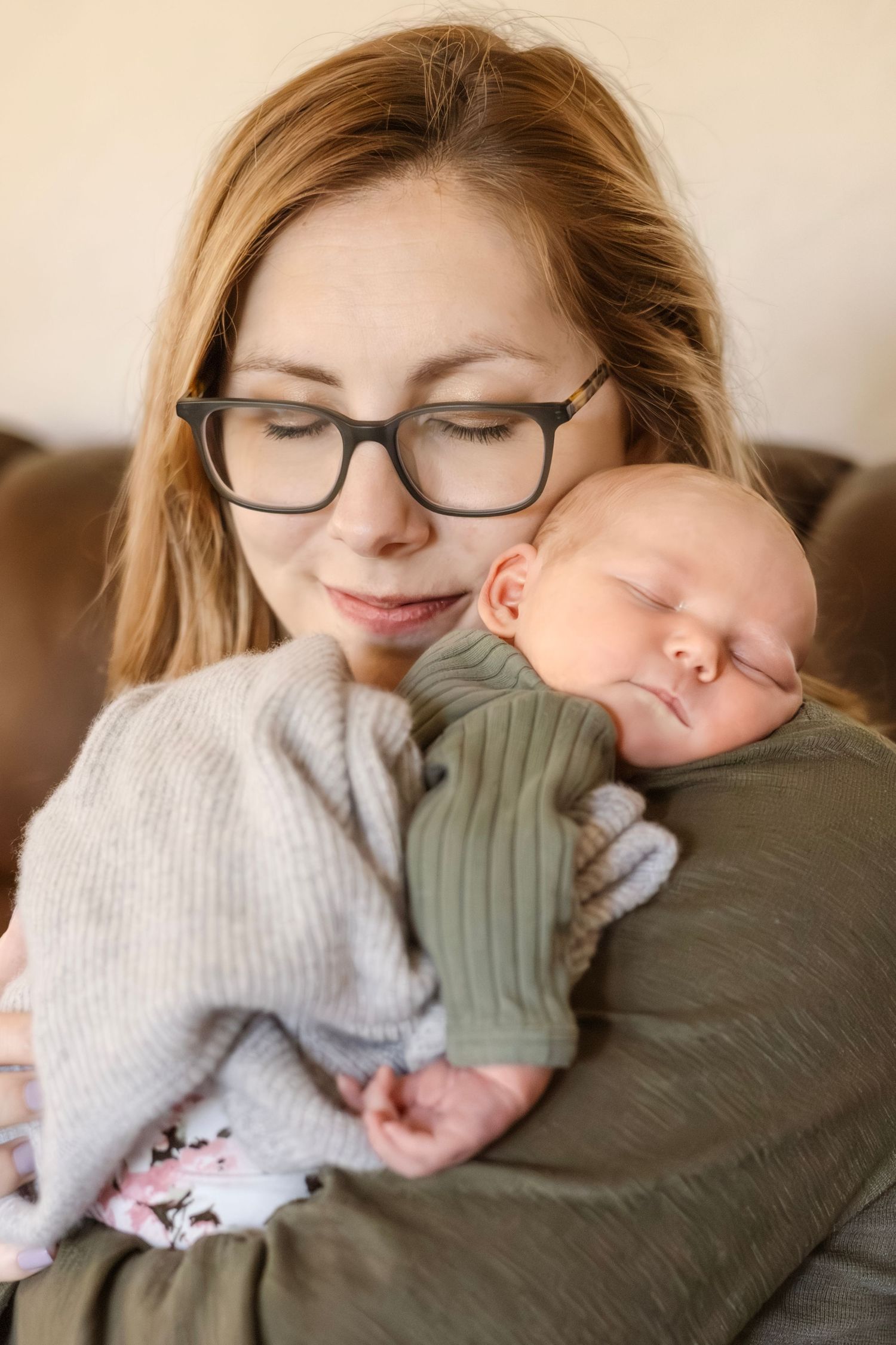 Tender moment captured in soft lighting showing closeness and warmth between parent and newborn.