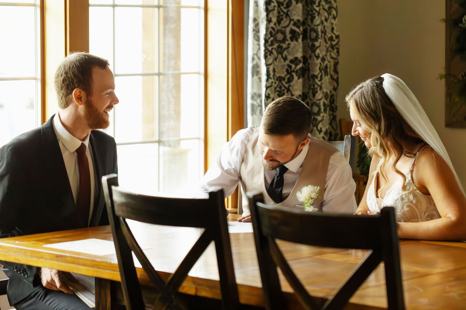 Couple in formal attire sits at a window table in an elegant restaurant during a romantic dinner date.