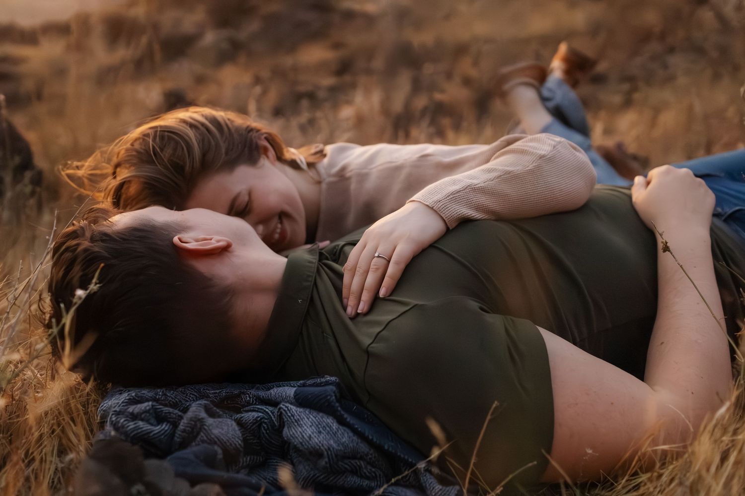 Couple relaxing together on ground in natural outdoor setting.