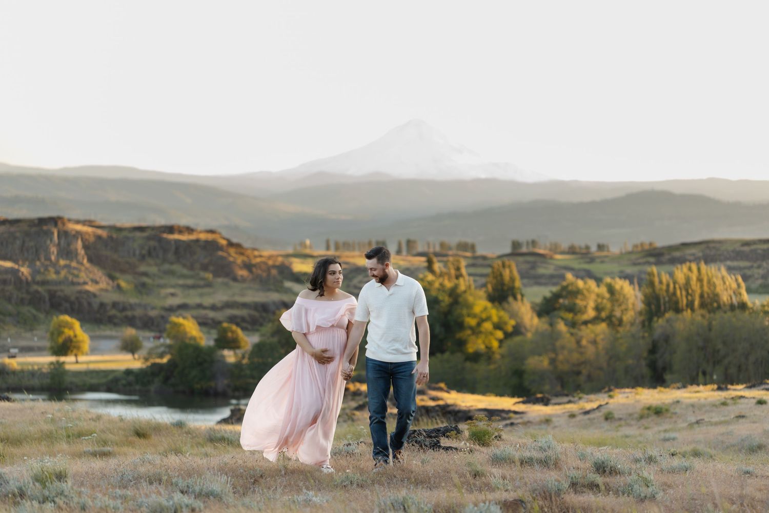 Couple strolling through scenic mountain landscape in evening light.